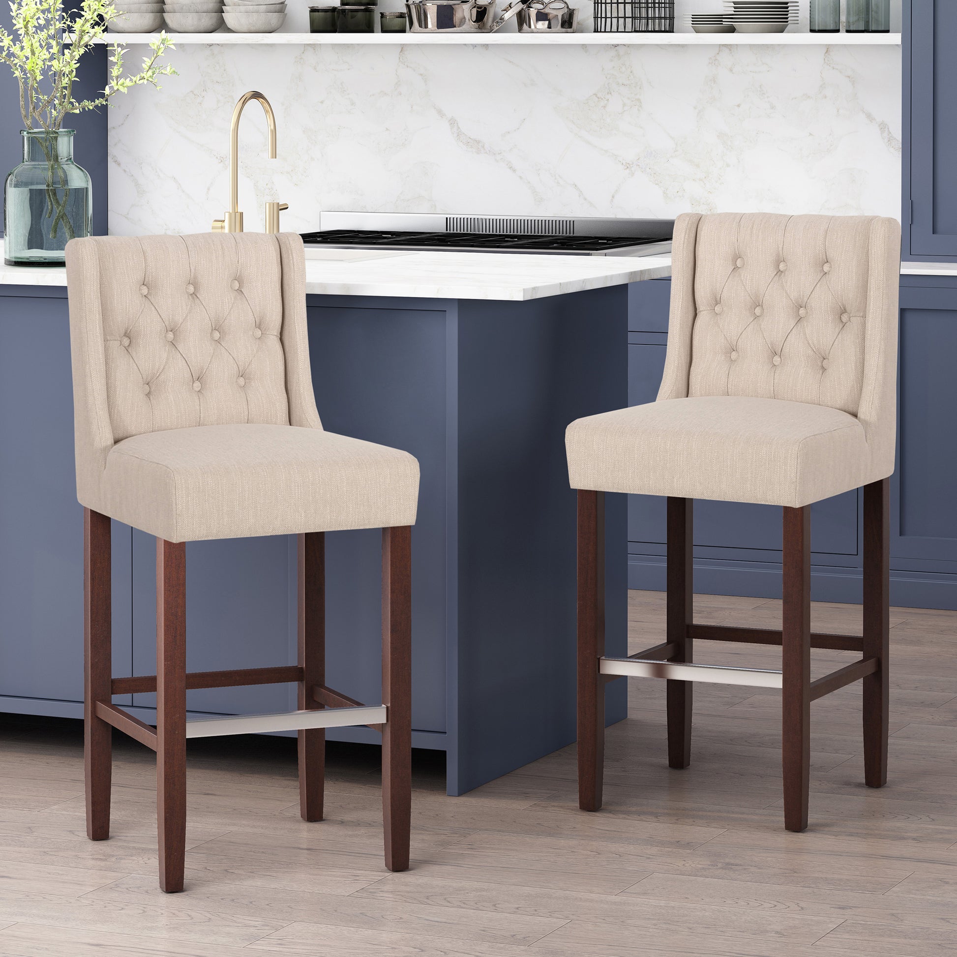 Tufted beige fabric bar stool with dark wood legs and metal footrest