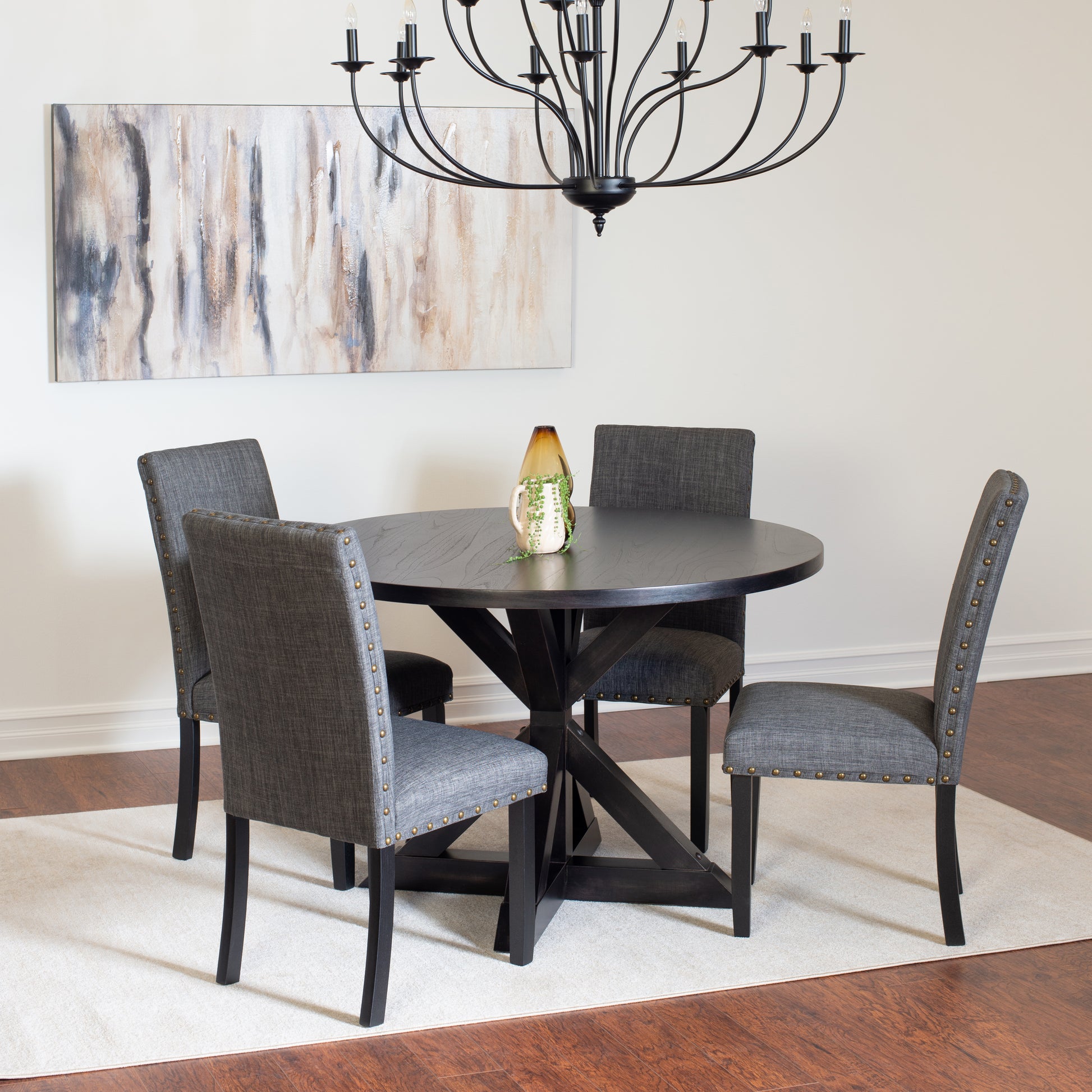 Dark wood round dining table with upholstered grey chairs
