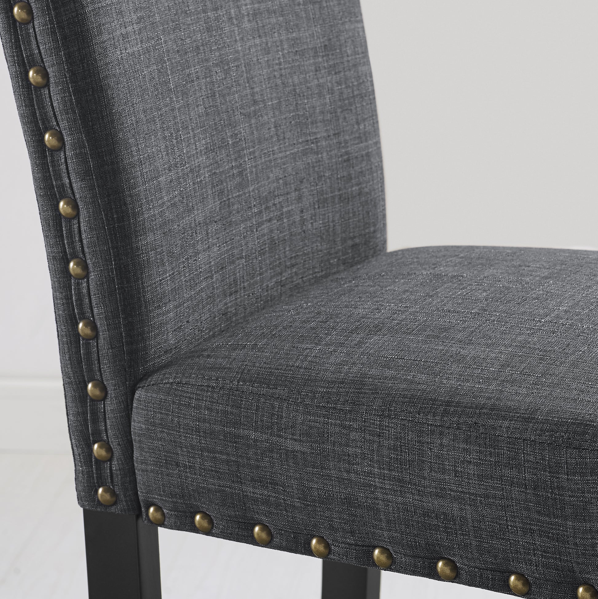 Charcoal upholstered dining chair with antique brass nailhead trim