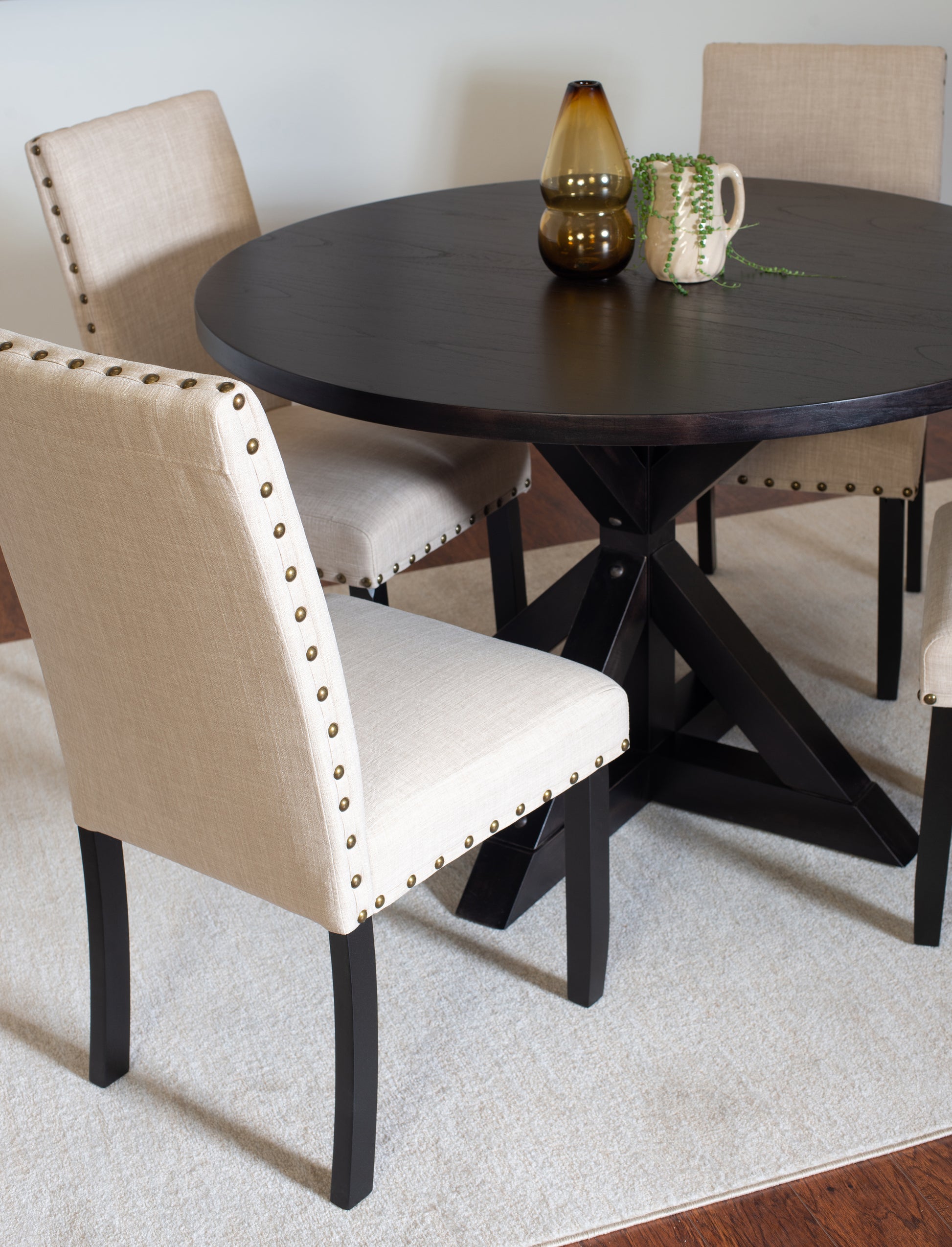 Tufted linen dining chair with brass nailhead trim and dark wood legs
