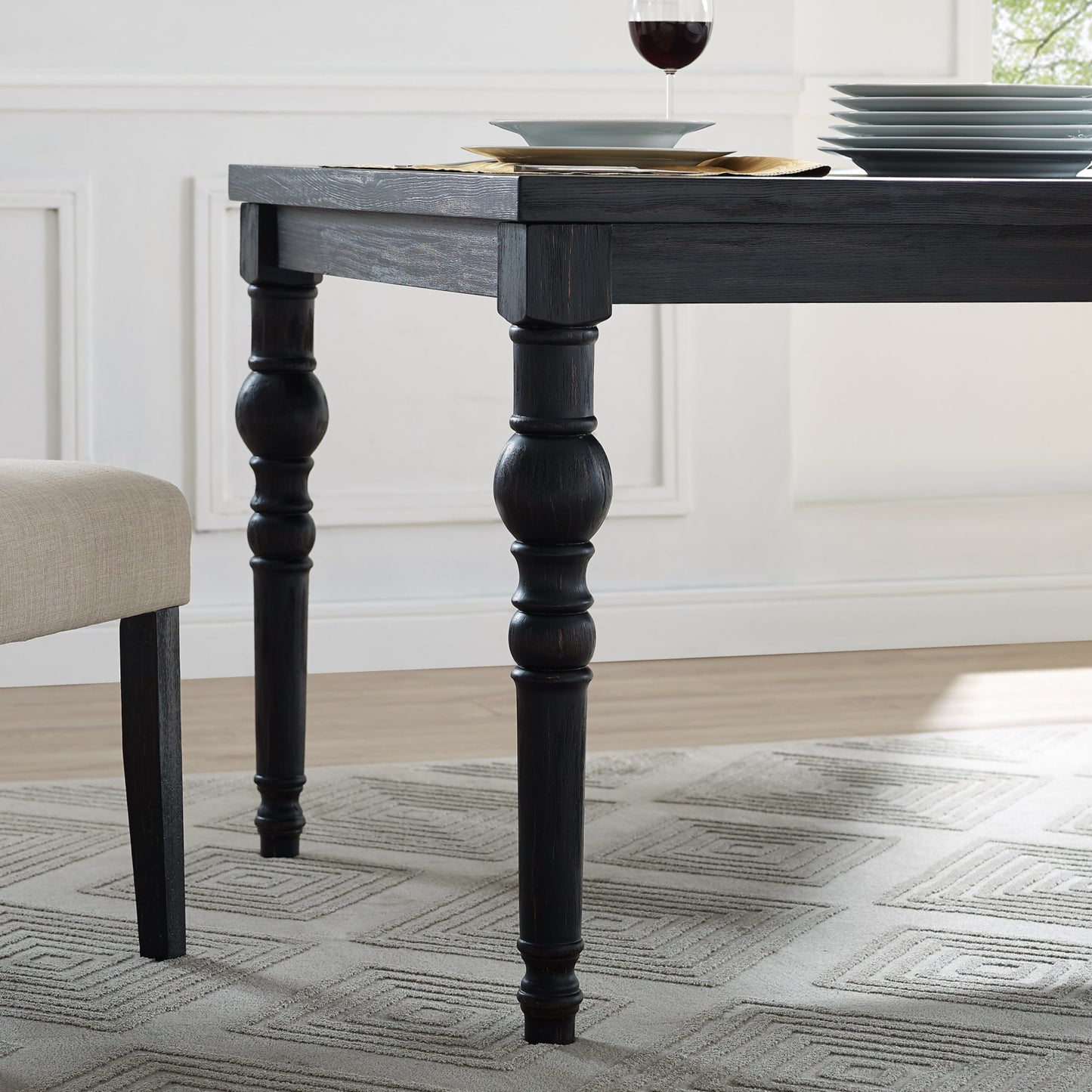 Dark wood dining table with turned legs on a geometric rug