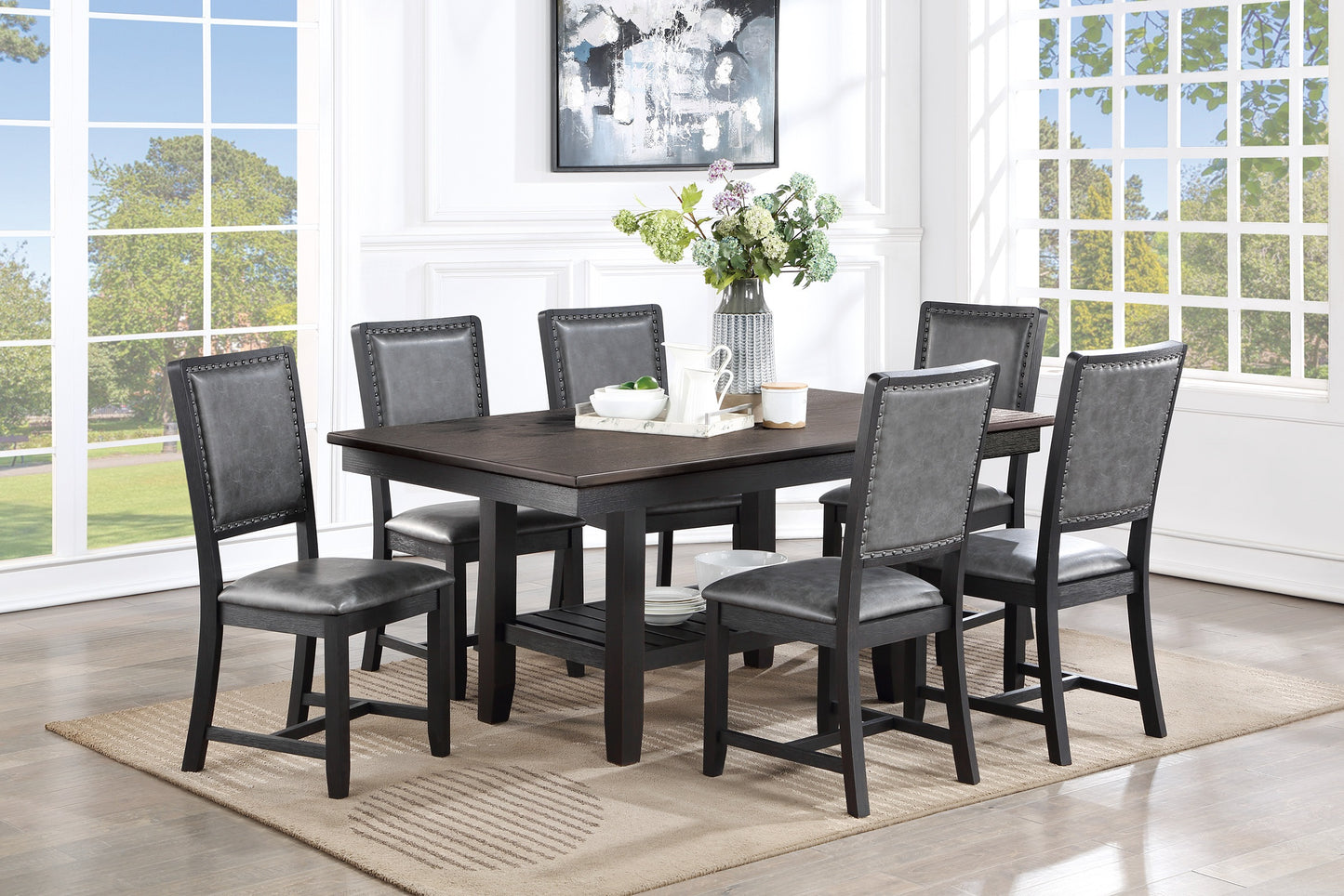 Dark wood dining table with six grey upholstered chairs and stud trim
