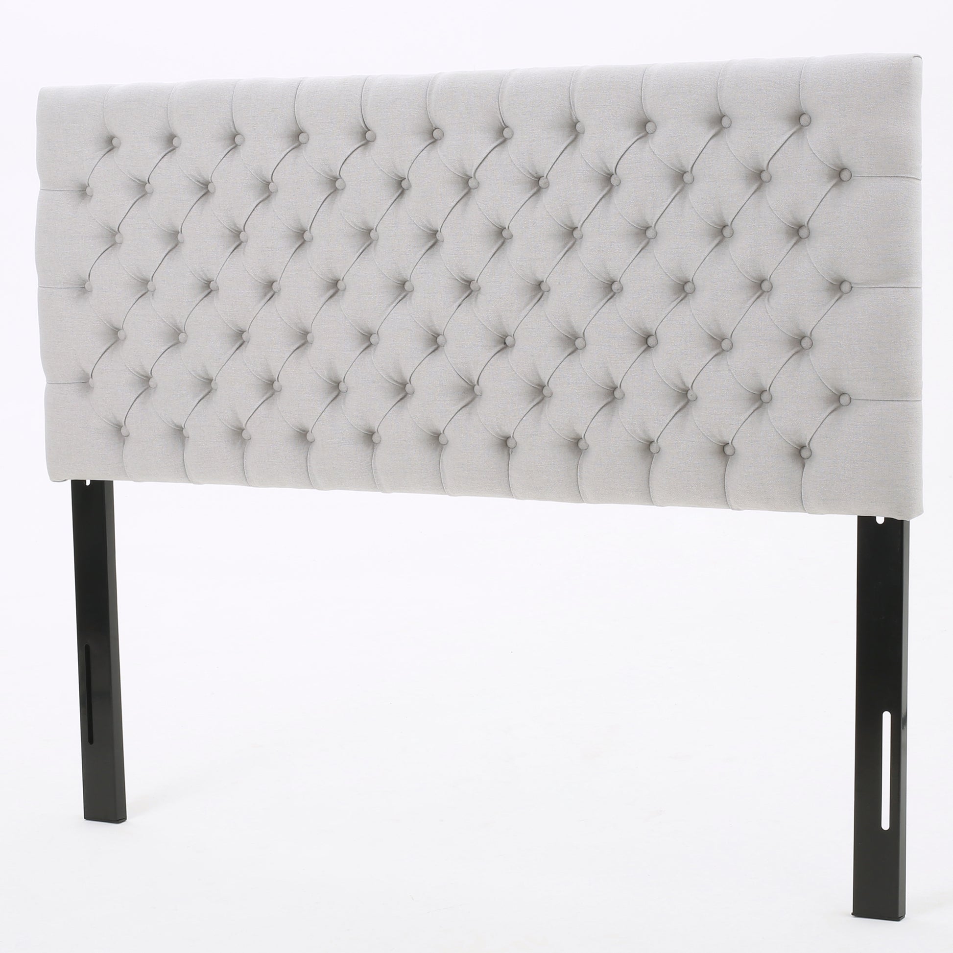 Light grey tufted fabric headboard with diamond stitching and black metal legs