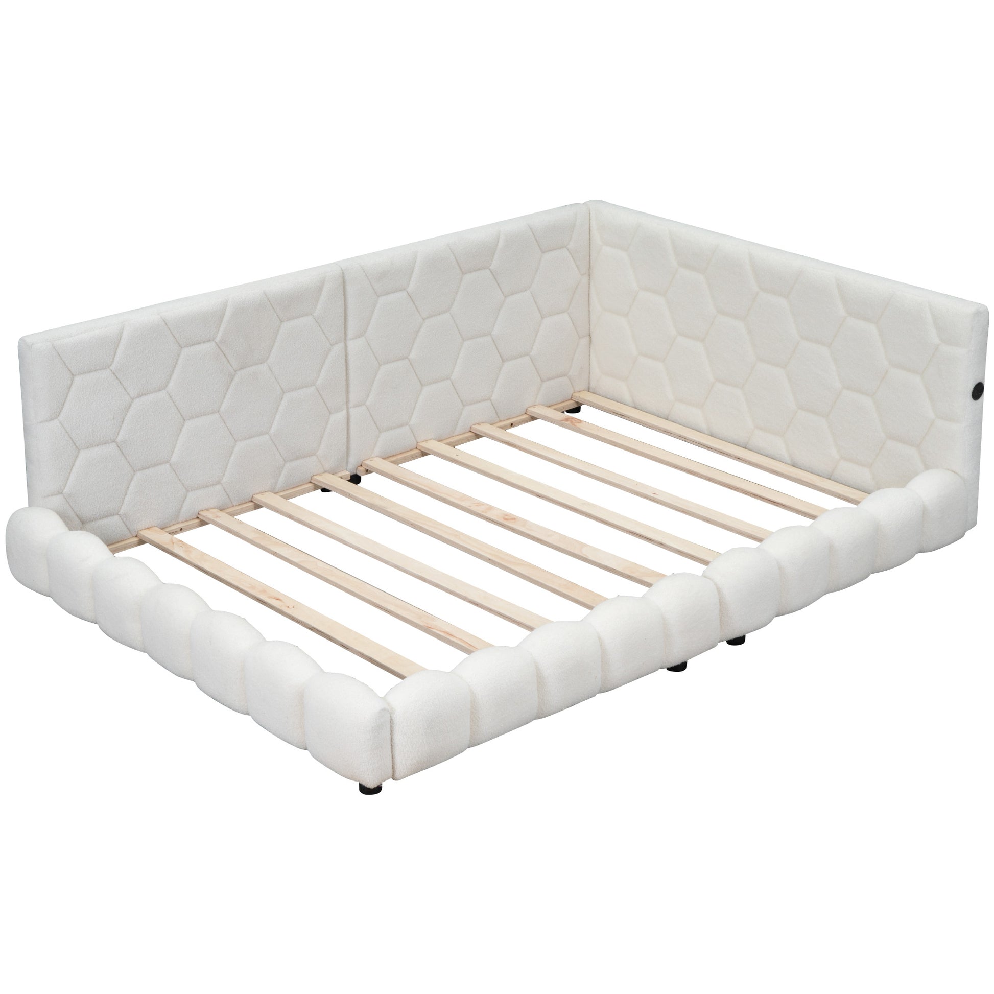 White upholstered bed frame with honeycomb pattern headboard and plush bumper sides