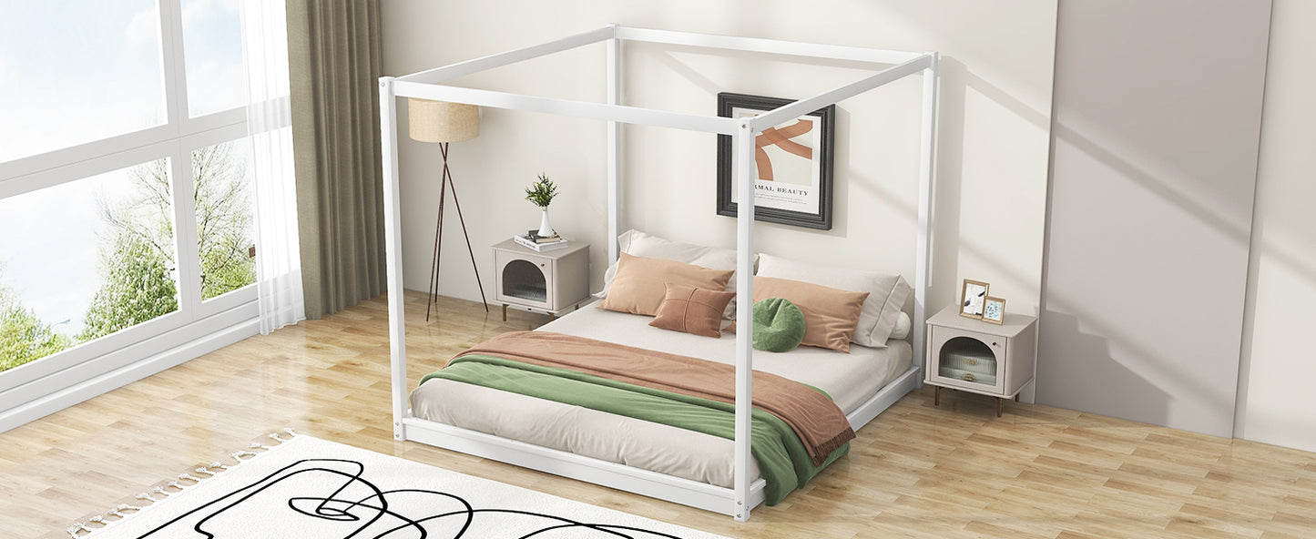 White metal canopy bed frame with plush bedding and accent pillows
