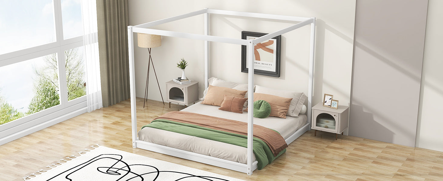 White metal canopy bed frame with plush bedding and accent pillows