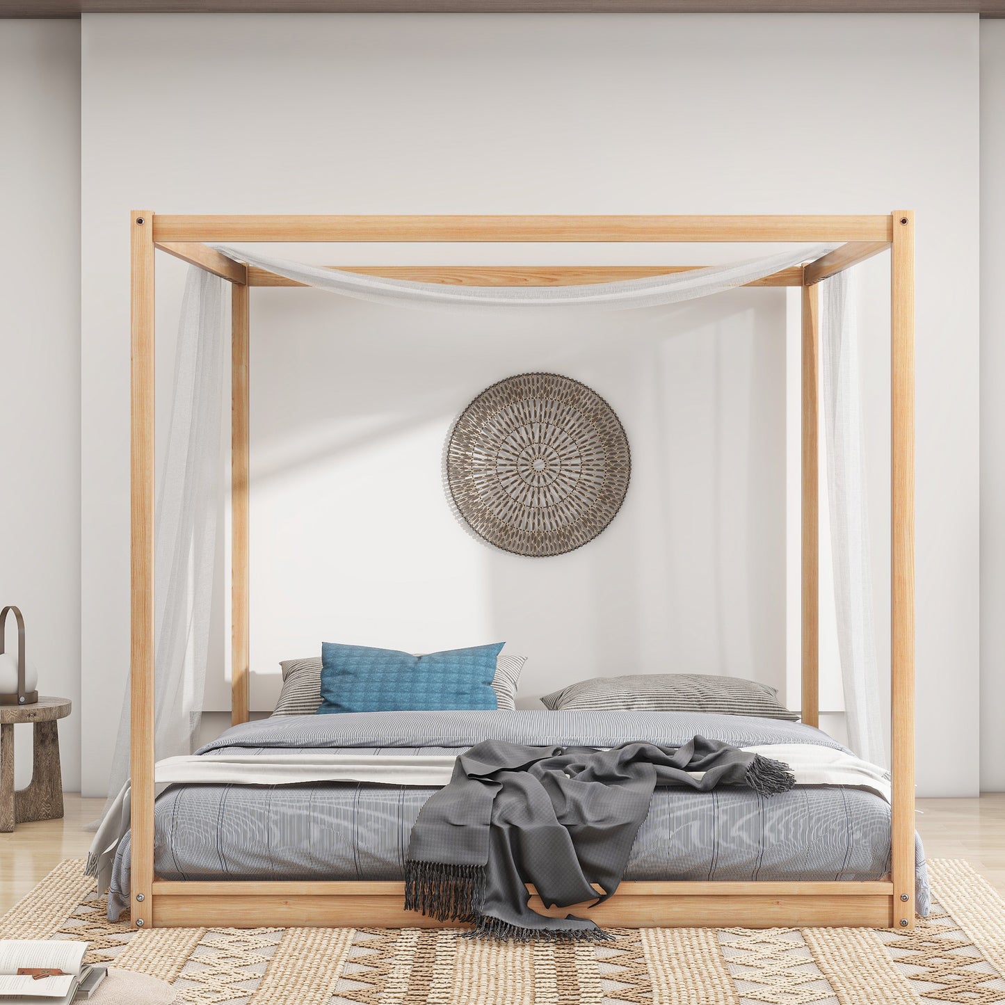 Natural wood fourposter bed with sheer drapes and striped bedding