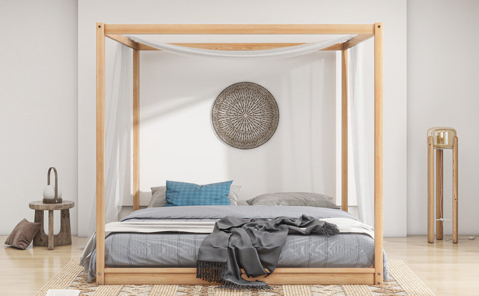 Natural wood fourposter bed with light drapes and grey bedding