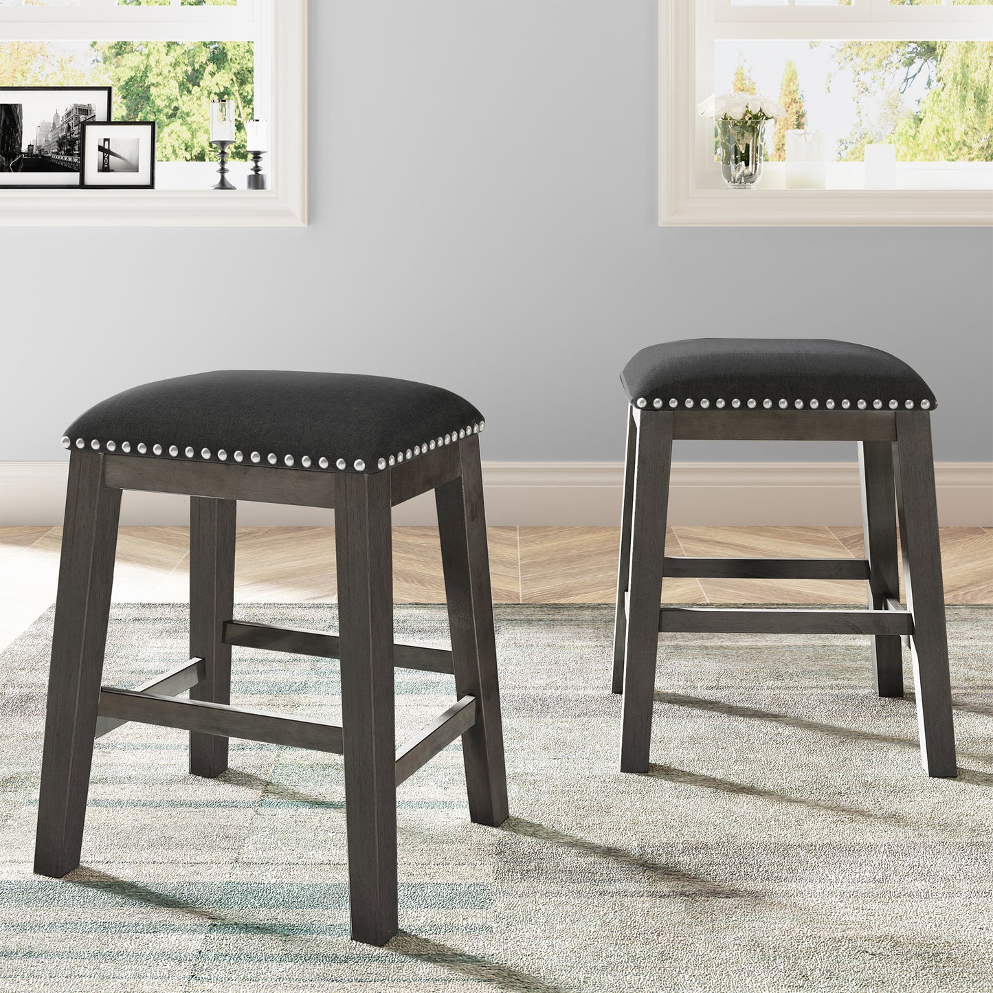Dark gray upholstered bar stool with silver nailhead trim and wooden legs