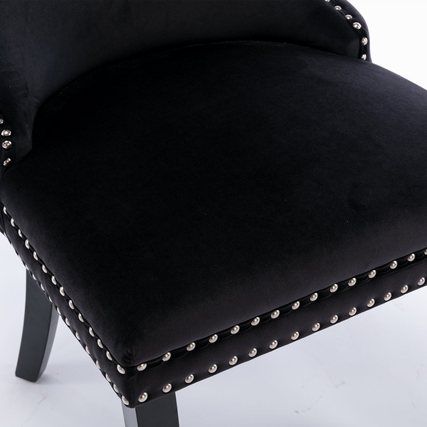 Black velvet accent chair with silver stud detailing and dark wood legs