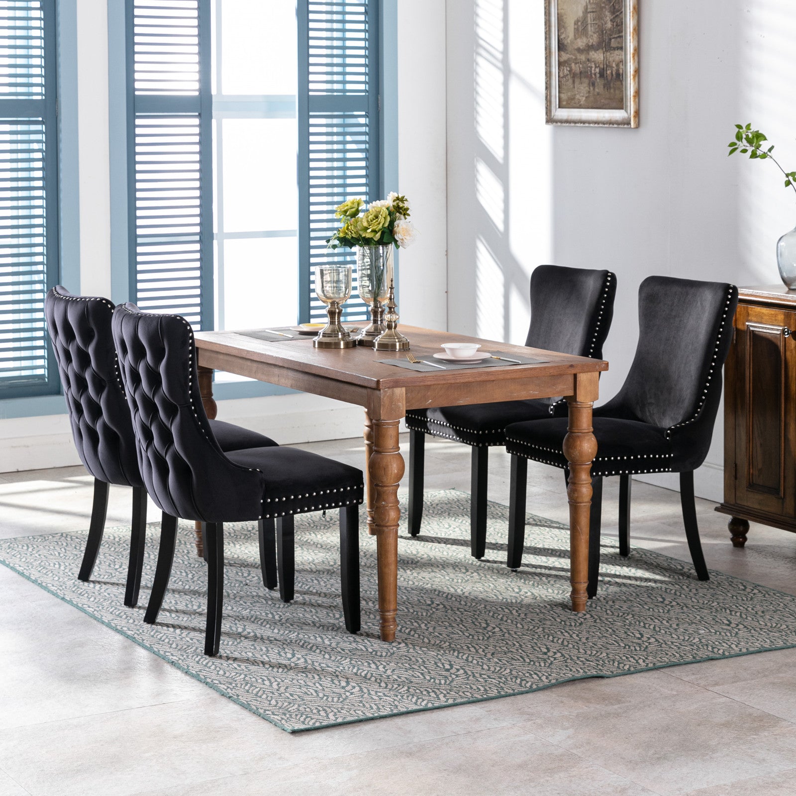 Black velvet tufted dining chairs with silver nailhead trim