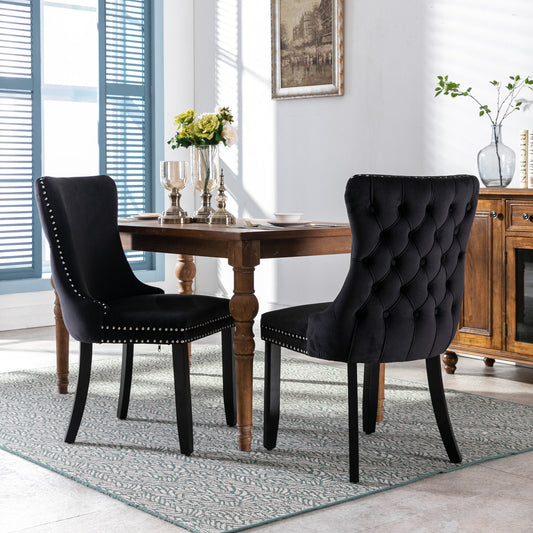Black velvet dining chair with tufted back and silver nailhead trim