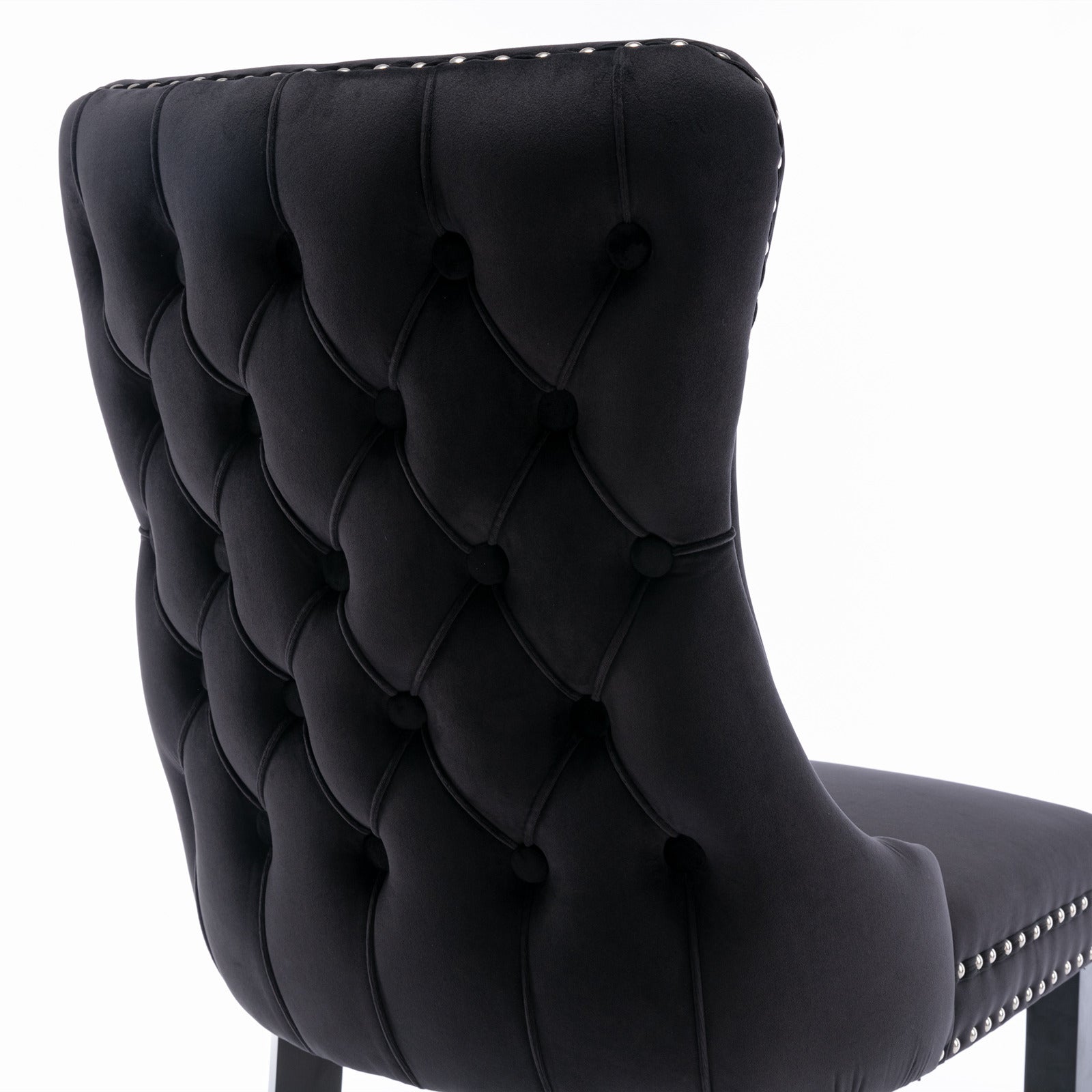 Black velvet tufted dining chair with silver nailhead trim details