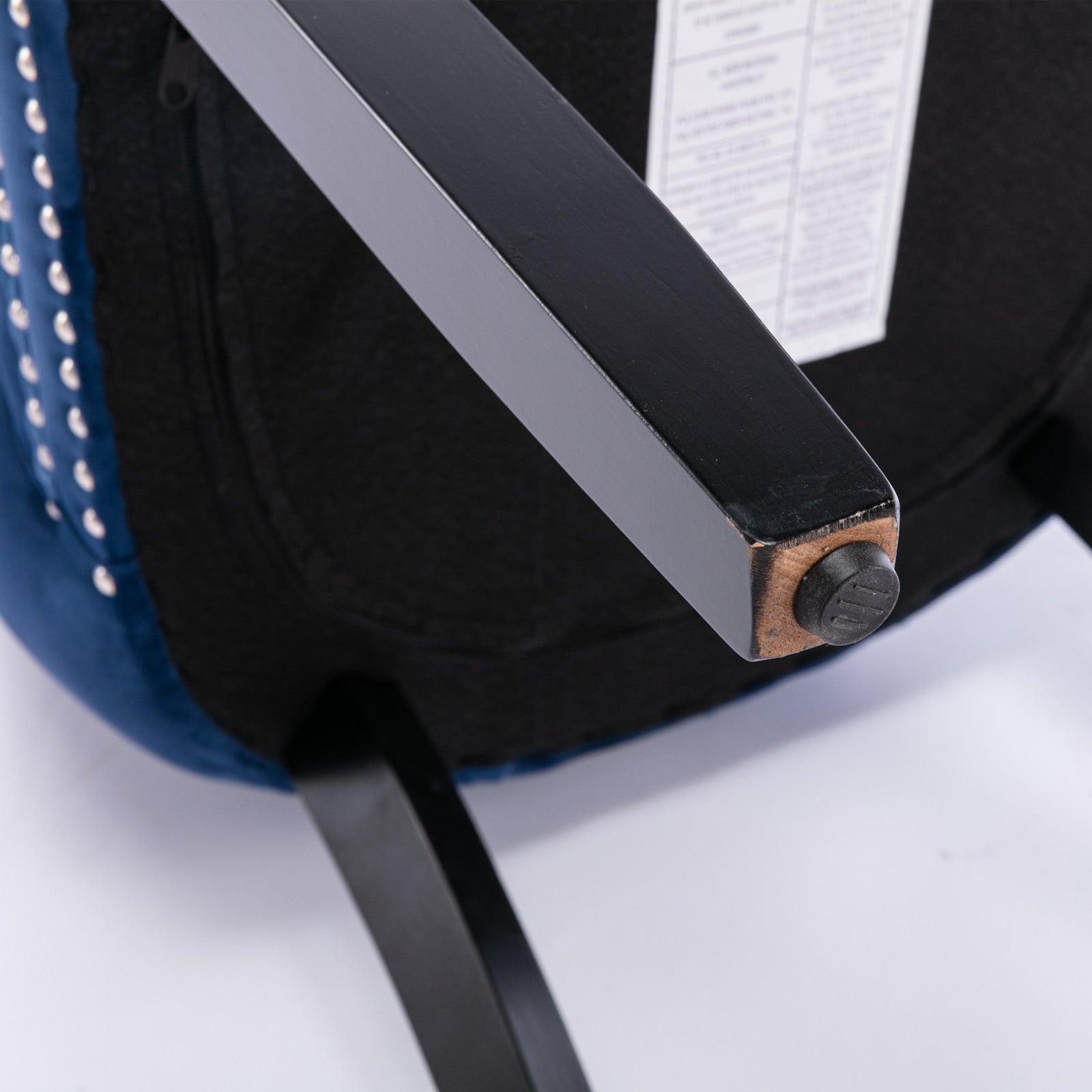 Closeup of blue velvet armchair leg with silver stud detail