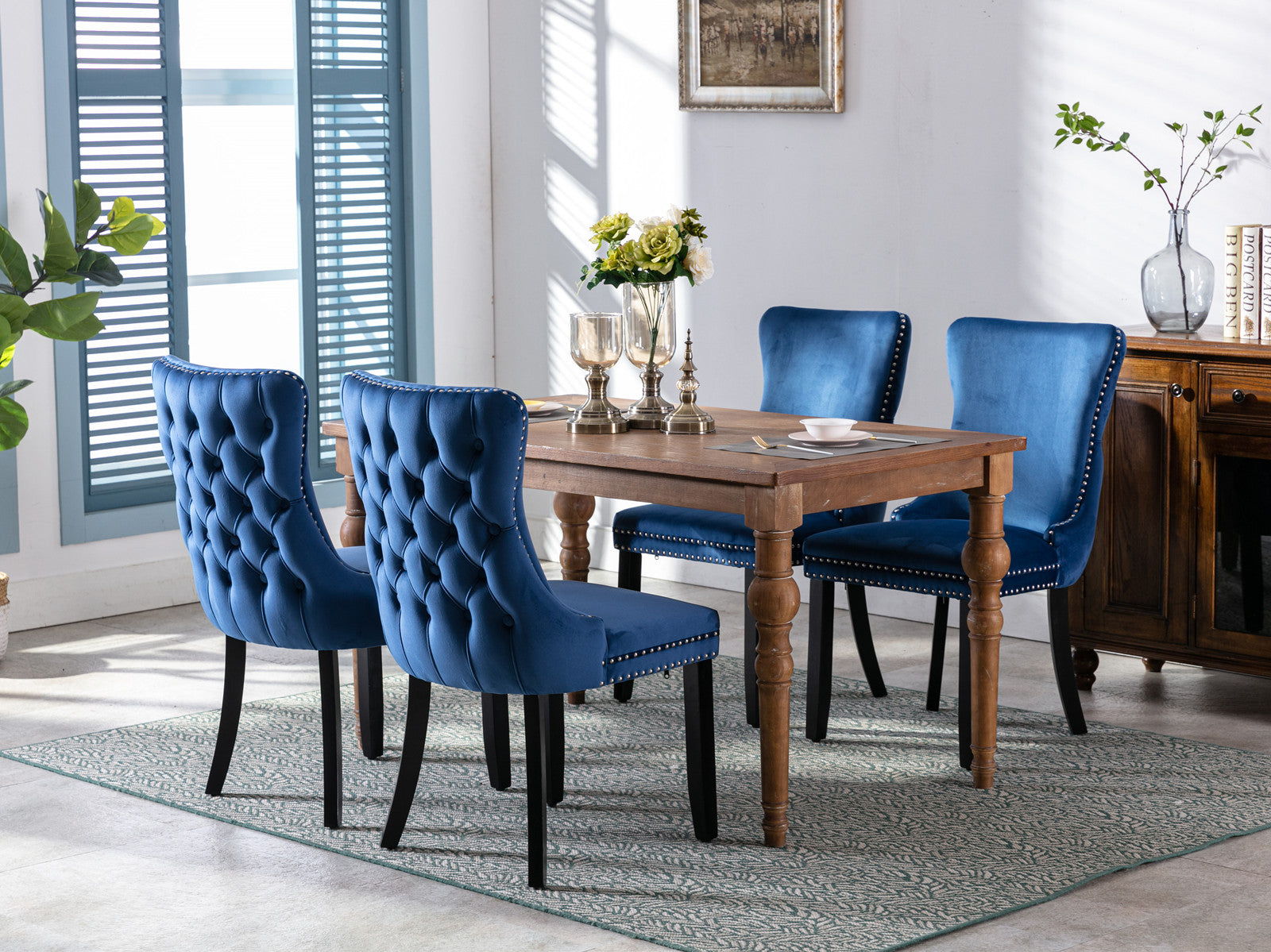 Tufted blue velvet dining chair with nailhead trim and dark wood legs
