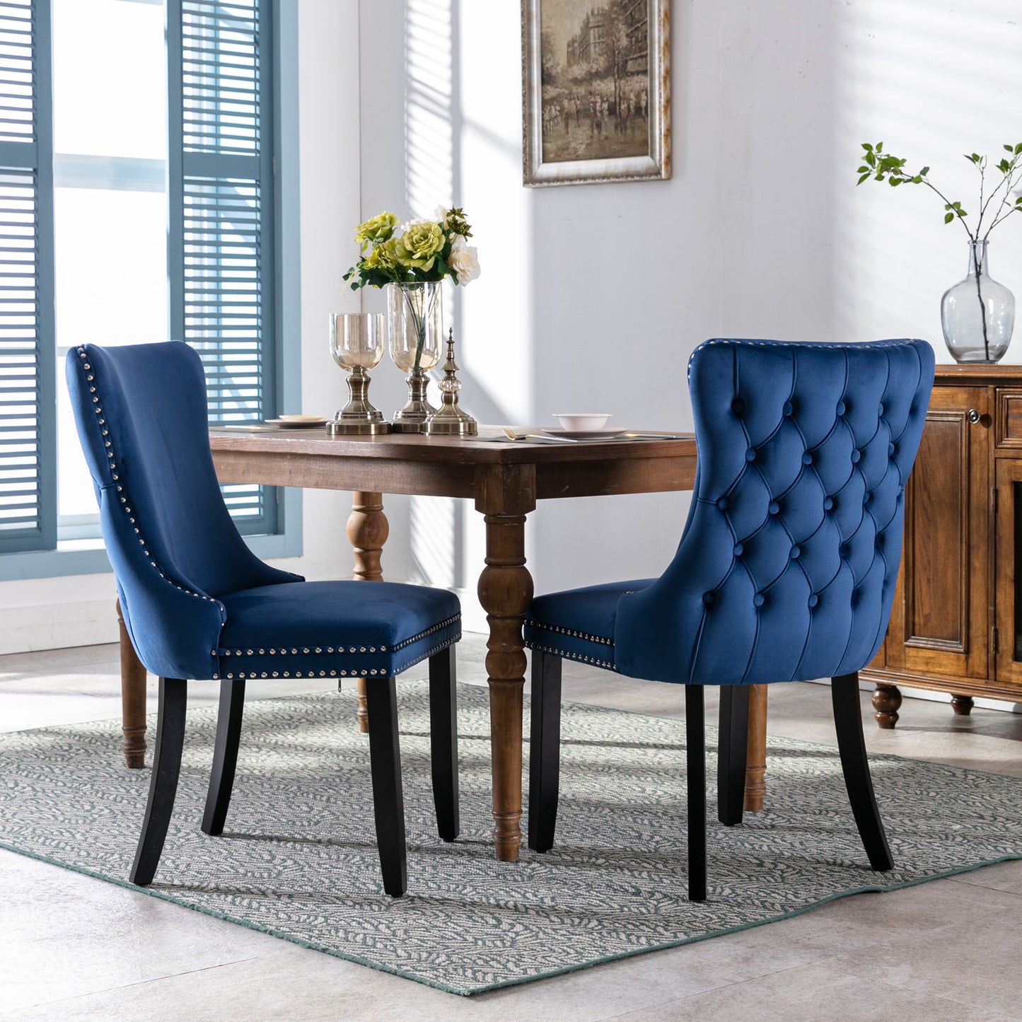 Deep blue velvet dining chair with tufted back and silver nailhead trim