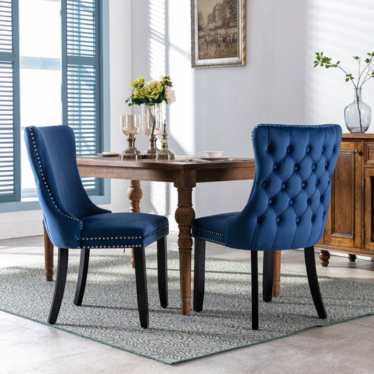 Deep blue velvet dining chair with tufted back and silver nailhead trim