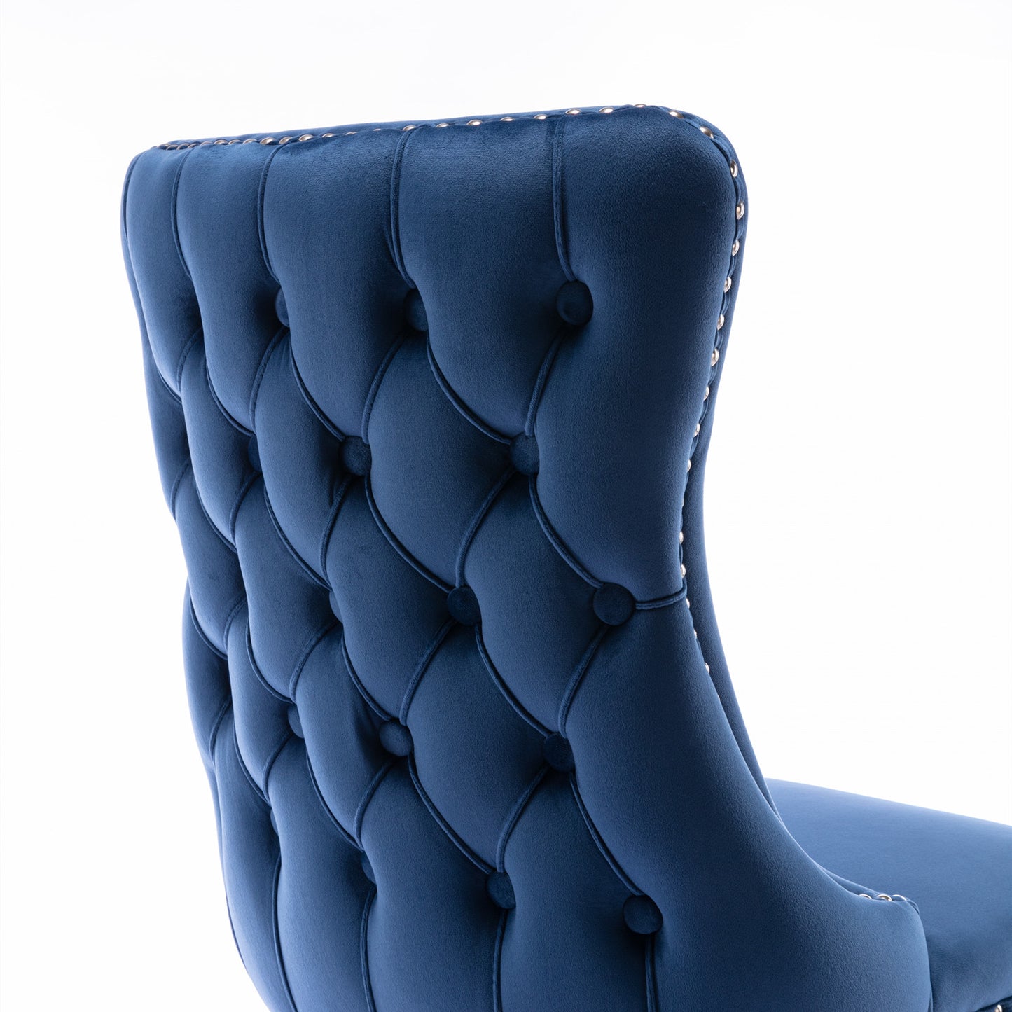 Deep blue velvet wingback chair with tufted back and nailhead trim