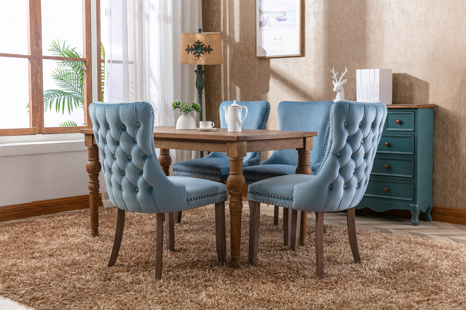 Light blue velvet dining chairs with tufted backs and nailhead trim