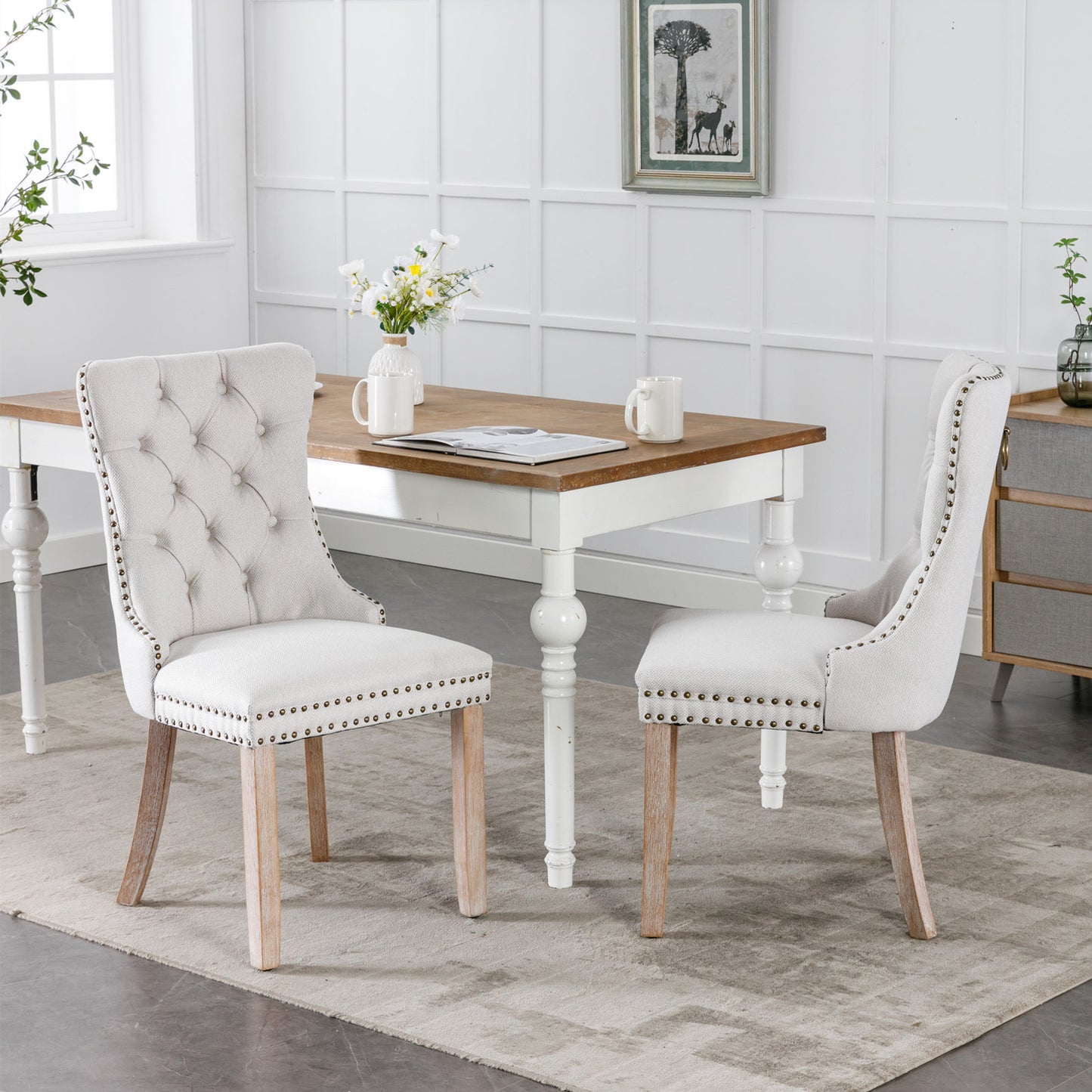 Tufted linen dining chair in light beige with brass nailhead trim and natural wood legs