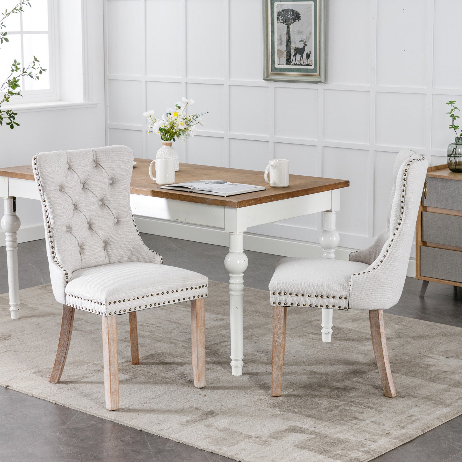 Tufted linen dining chair in light beige with brass nailhead trim and natural wood legs