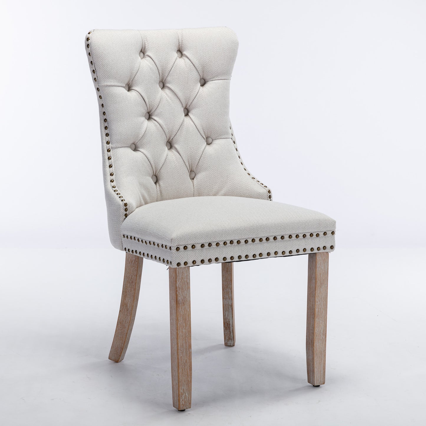 Tufted beige fabric dining chair with bronze nailhead trim and light wood legs