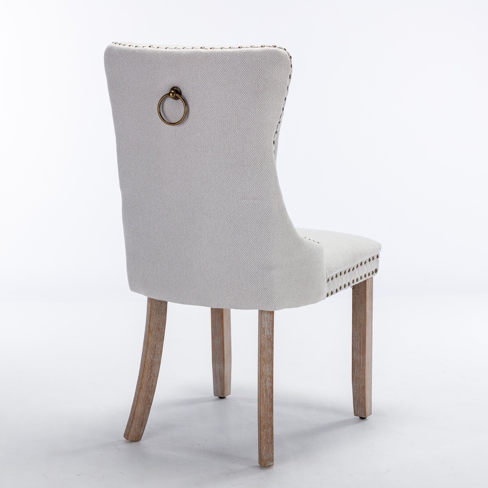 Light grey fabric dining chair with antique brass ring pull and nailhead trim