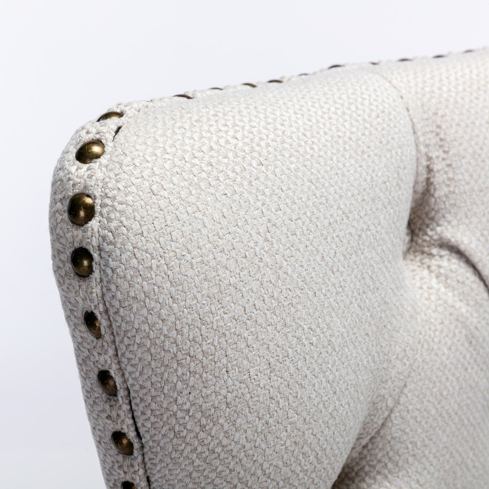 Beige textured fabric armchair with brass nailhead trim detail