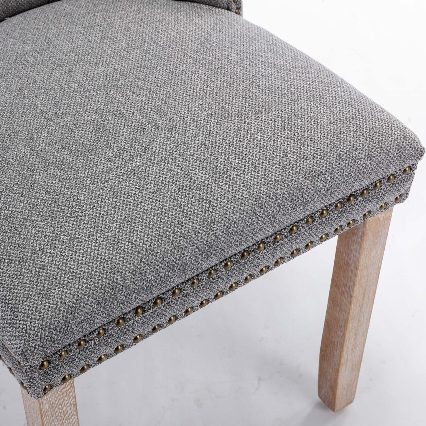 Gray upholstered dining chair seat with brass nailhead trim
