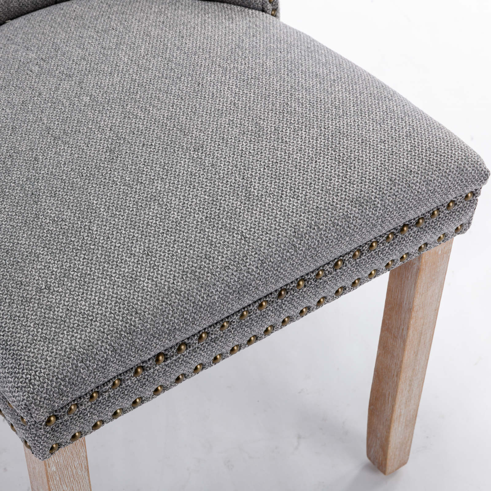Gray upholstered dining chair seat with brass nailhead trim