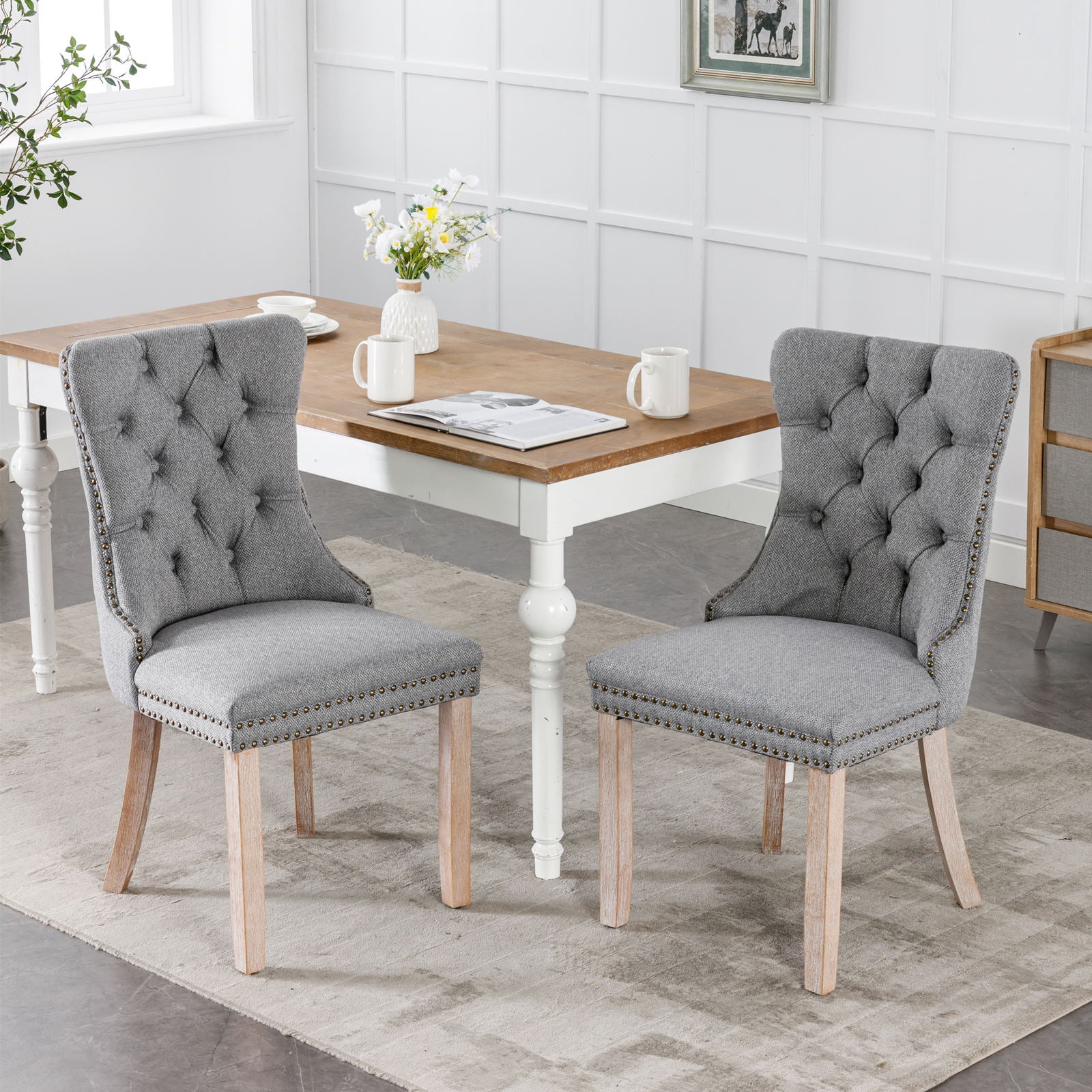 Grey upholstered dining chair with tufted back and nailhead trim
