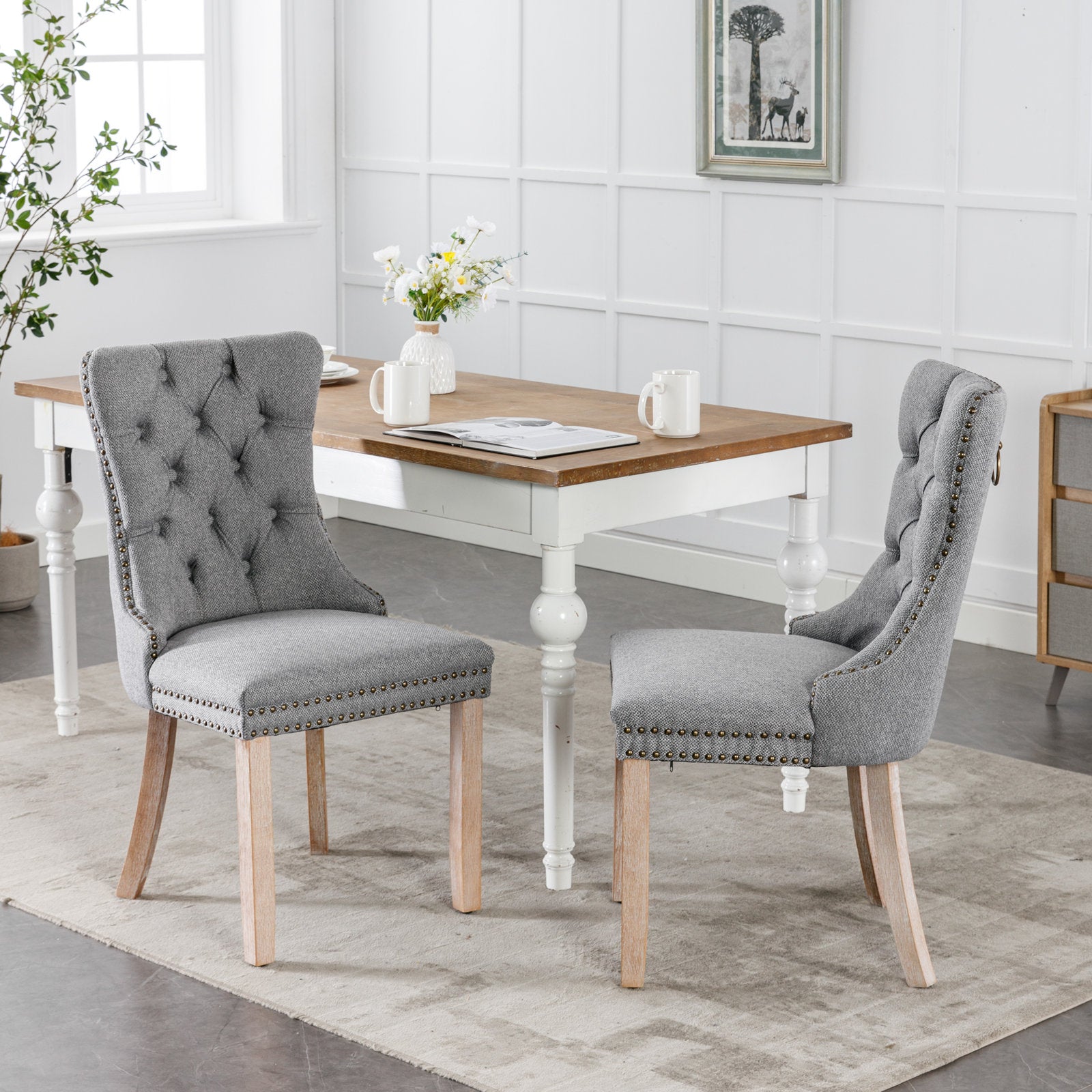 Grey upholstered dining chair with tufted back and nailhead trim