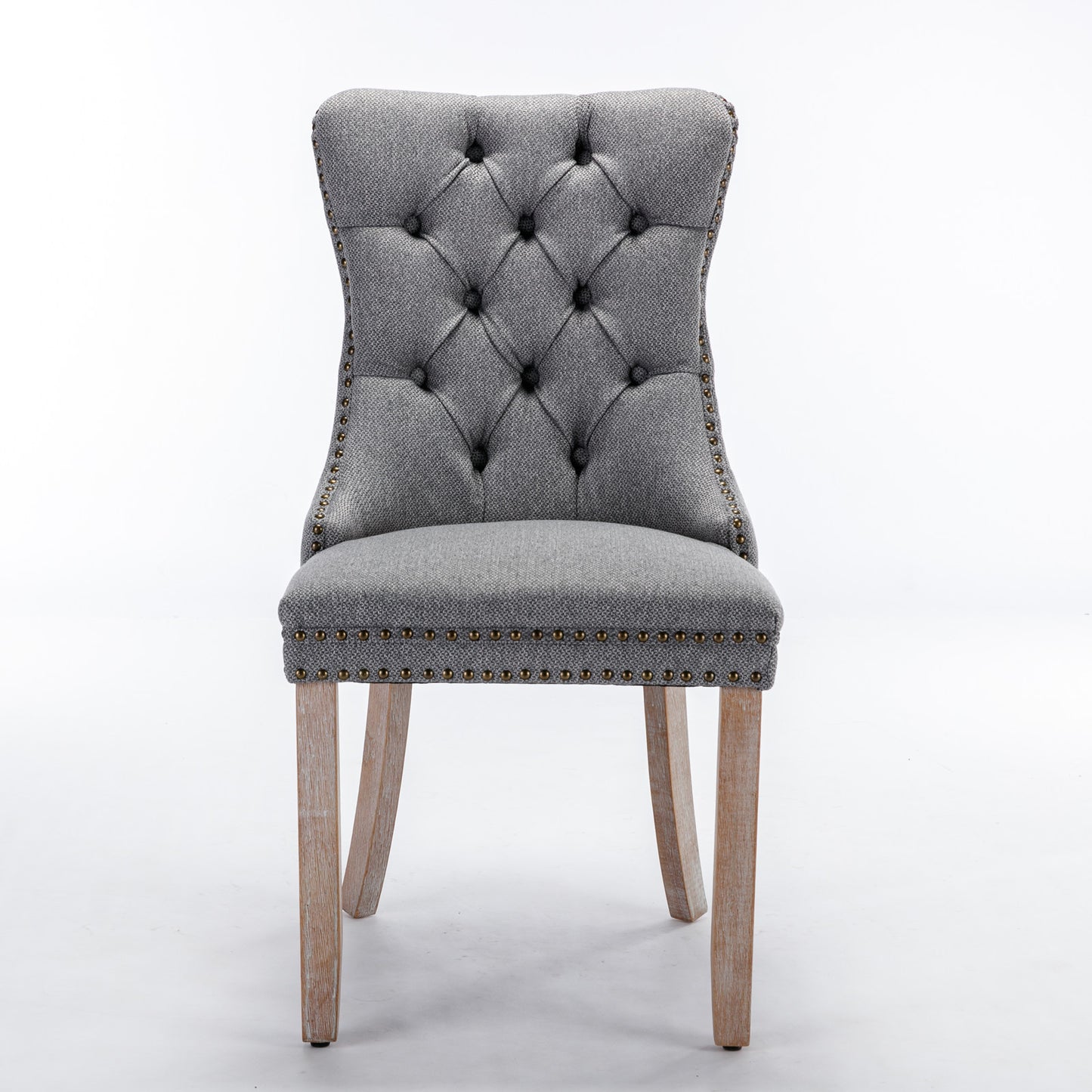 Grey upholstered dining chair with tufted back and nailhead trim