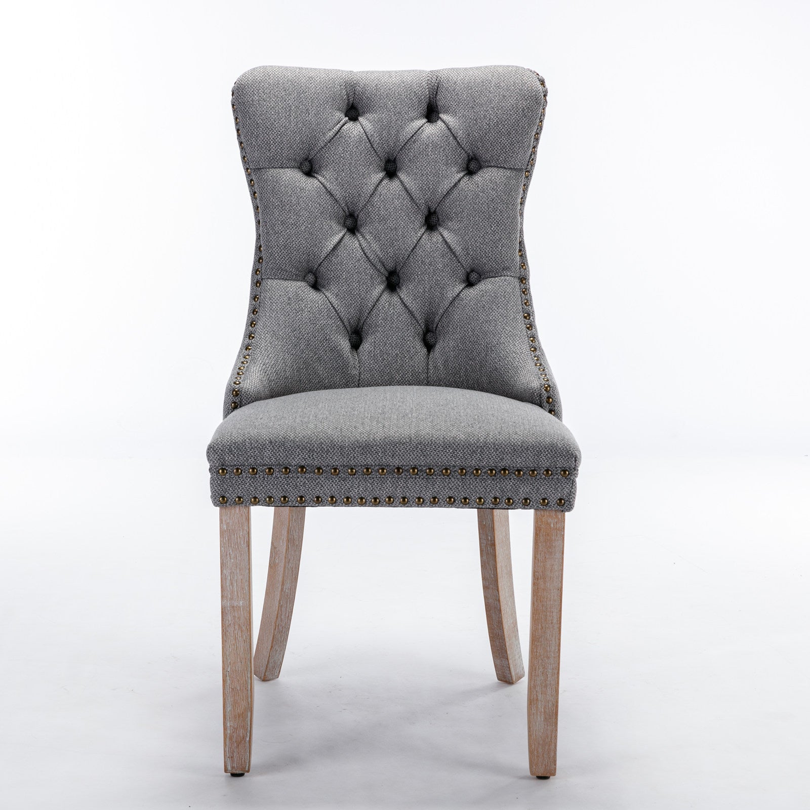 Grey upholstered dining chair with tufted back and nailhead trim