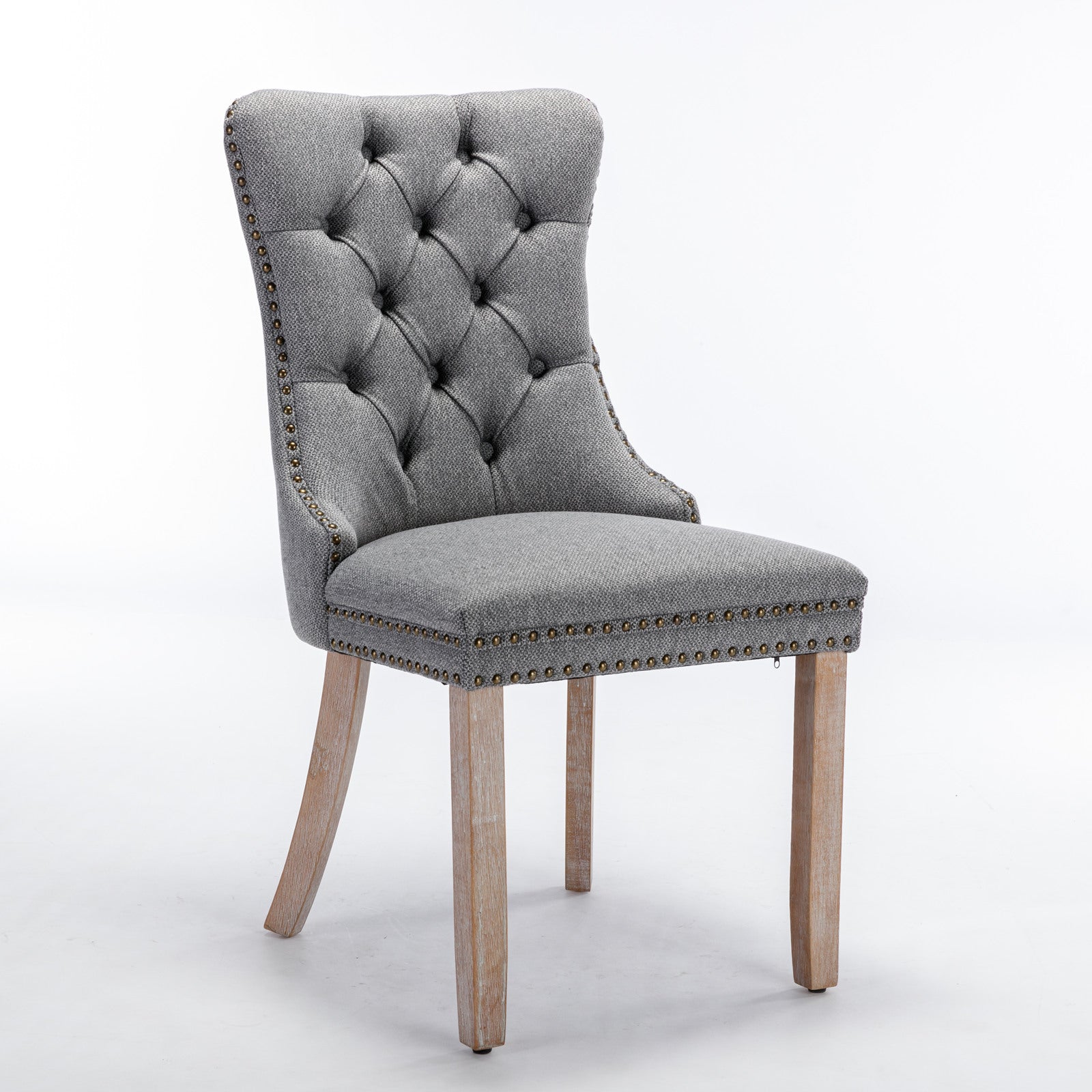 Grey tufted upholstered dining chair with brass nailhead trim and wooden legs