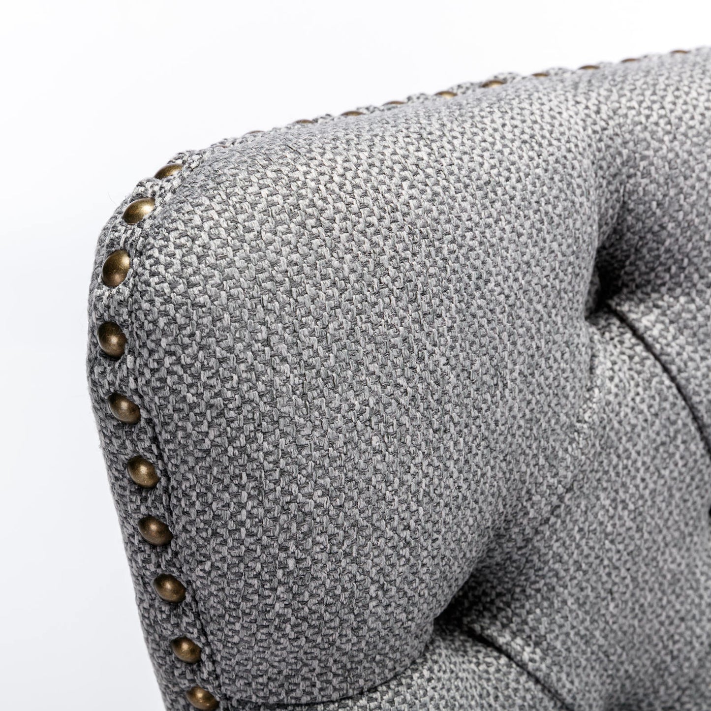 Tufted gray fabric armchair with brass nailhead trim detail