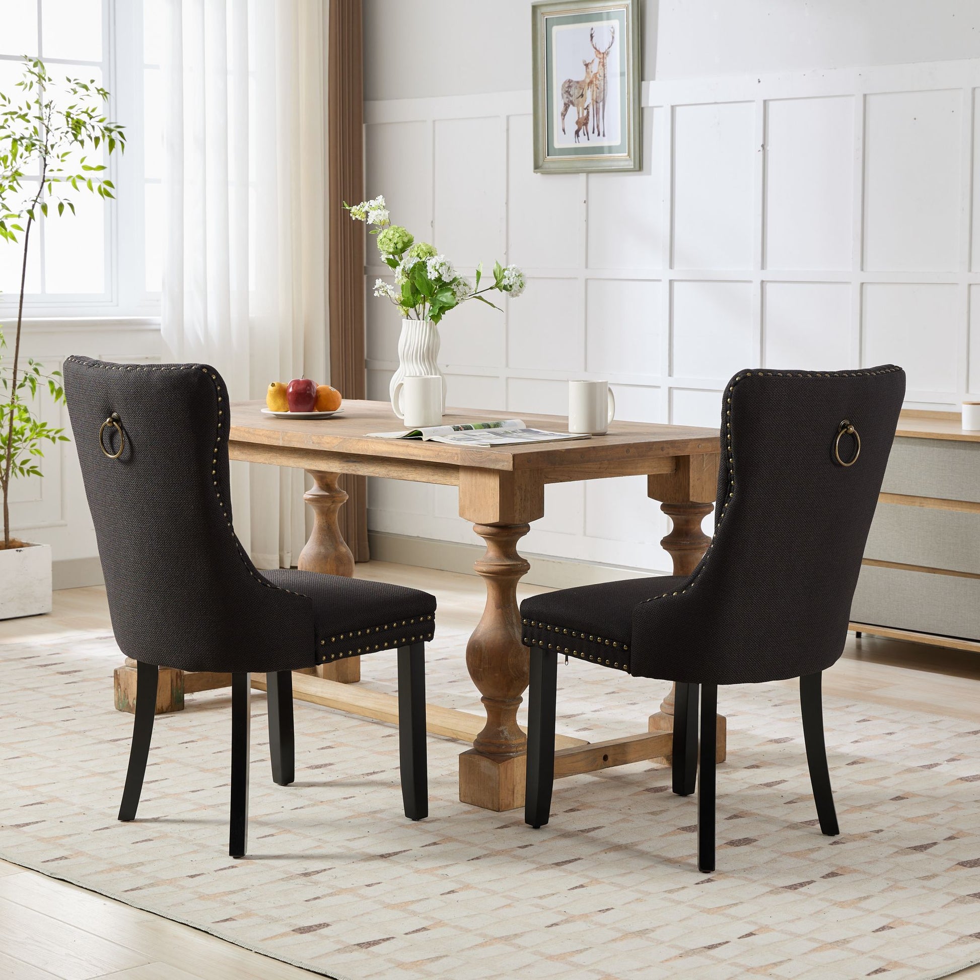 Dark grey upholstered dining chair with brass studs and ring pull