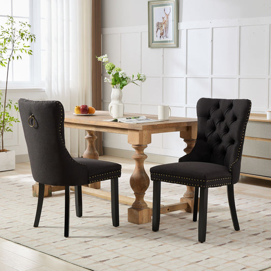 Tufted charcoal fabric dining chair with brass nailhead trim and ring pull