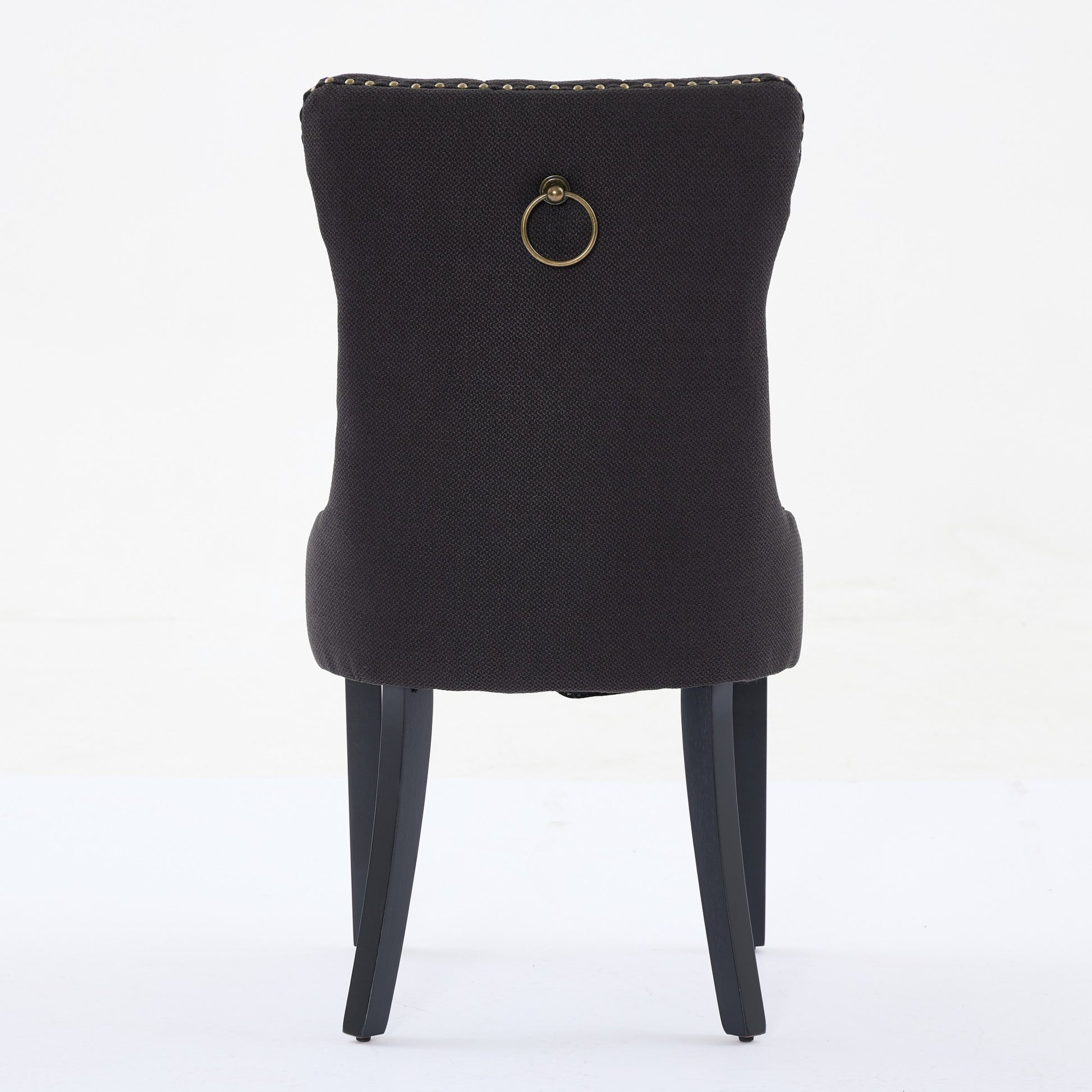 Dark gray upholstered dining chair with brass ring pull and nailhead trim