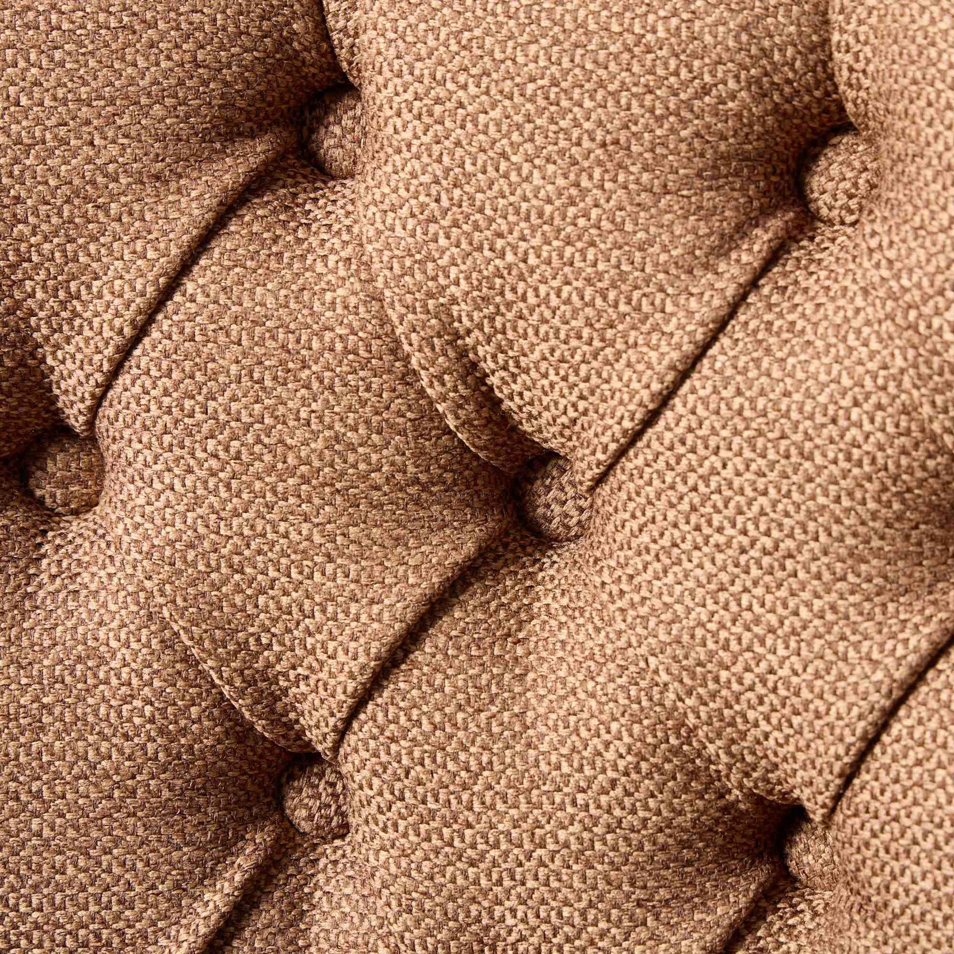 Closeup of tufted brown textured fabric upholstery