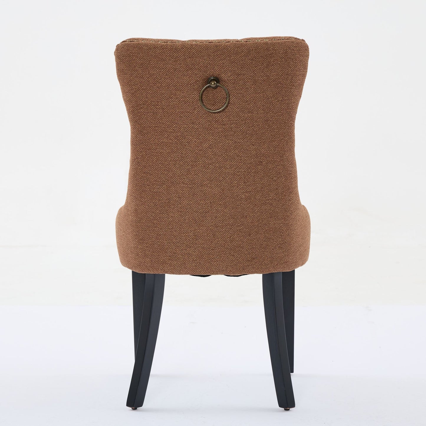 Brown upholstered dining chair with brass ring detail on back