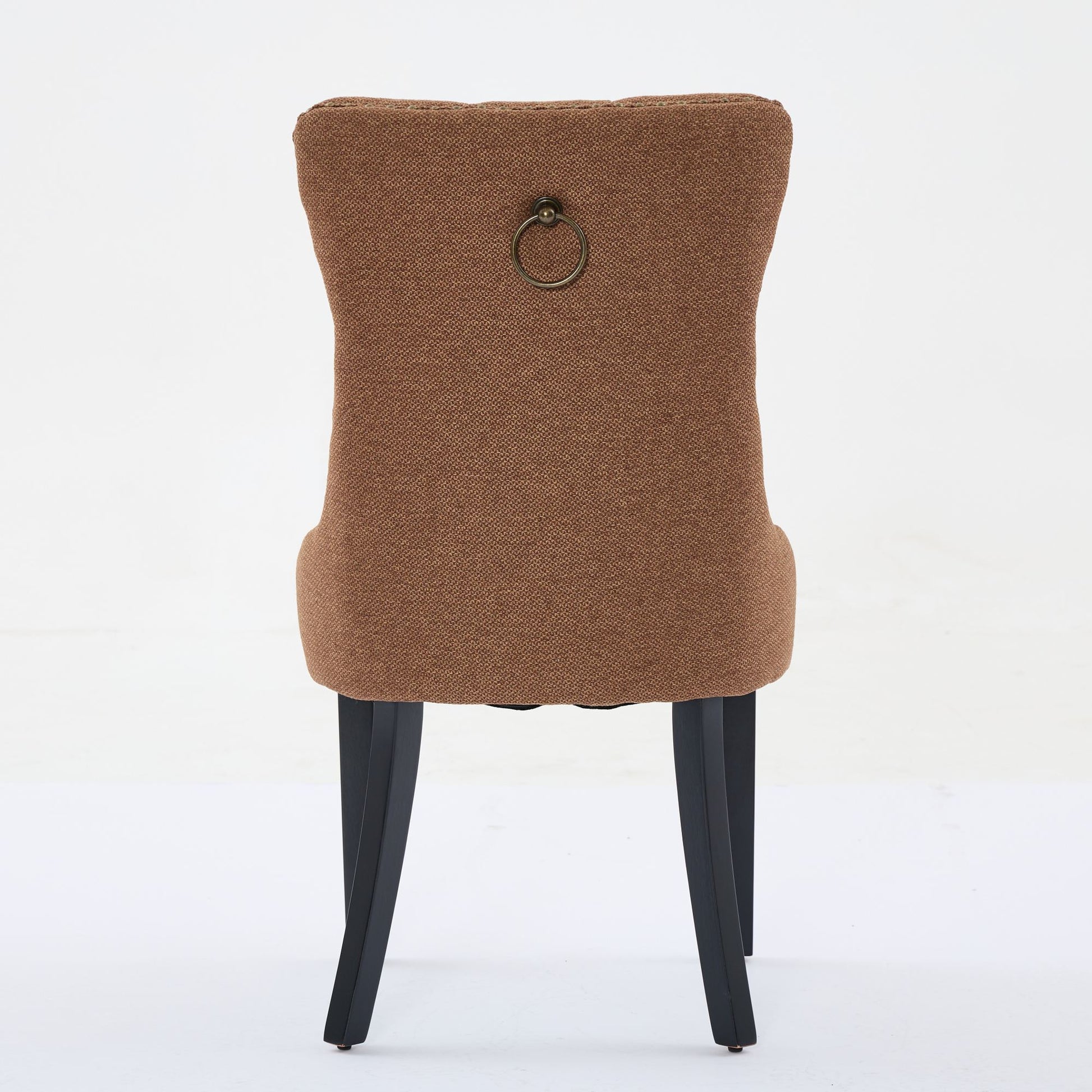 Brown upholstered dining chair with brass ring detail on back