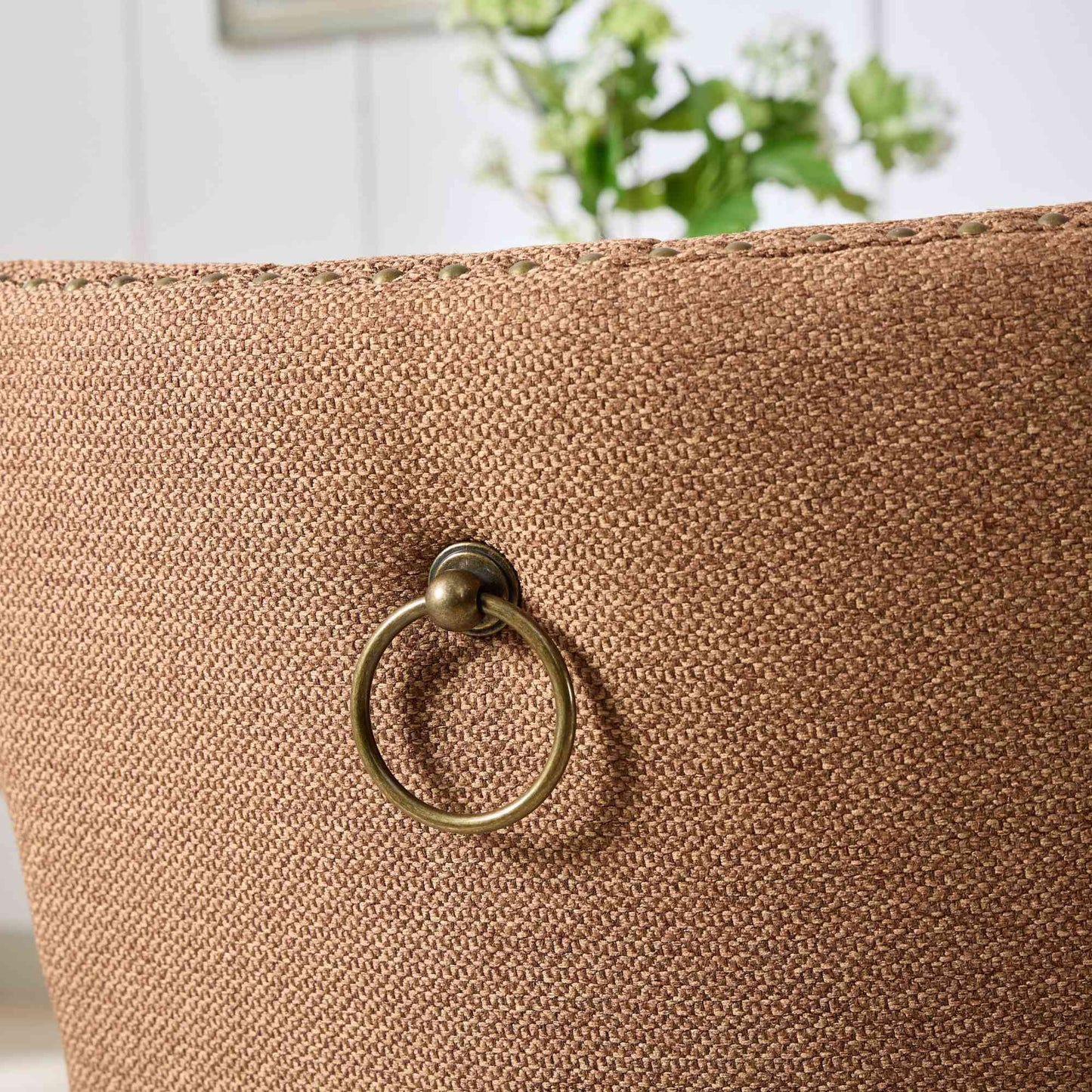 Brown textured armchair with brass ring pull detail