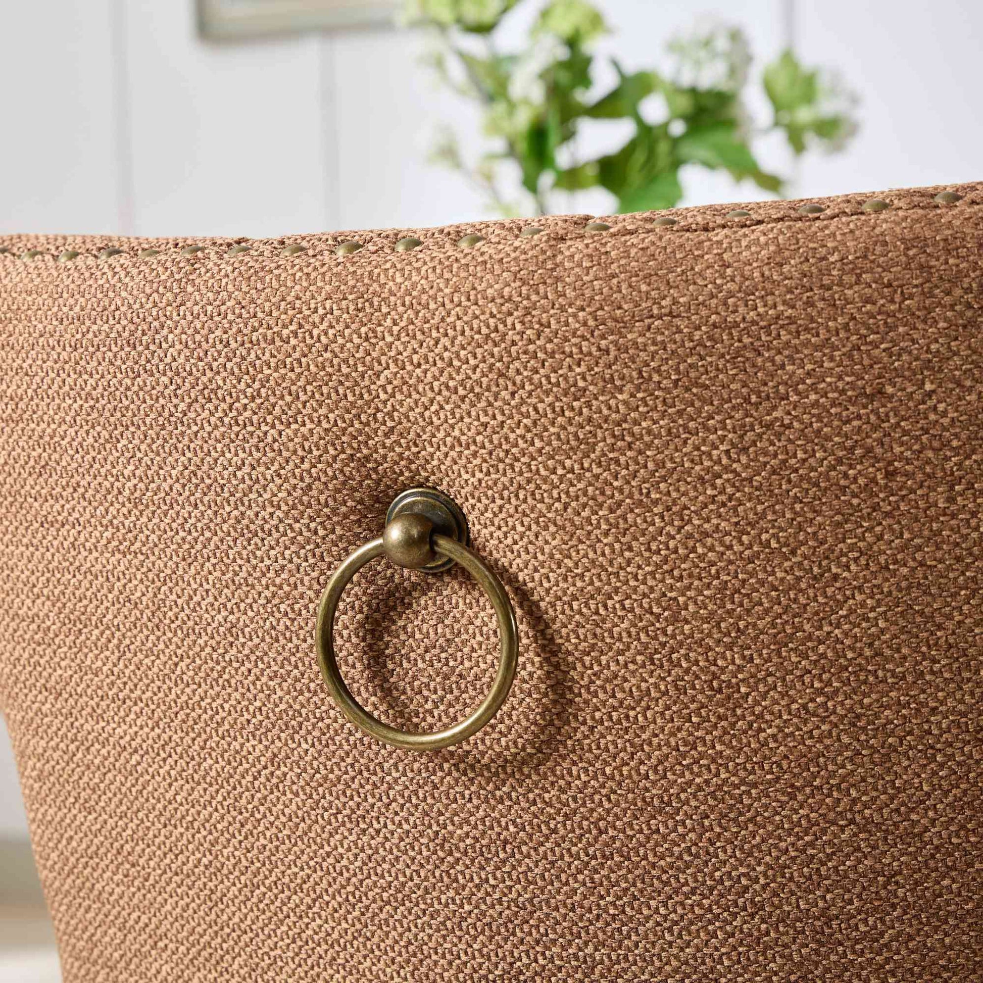 Brown textured armchair with brass ring pull detail