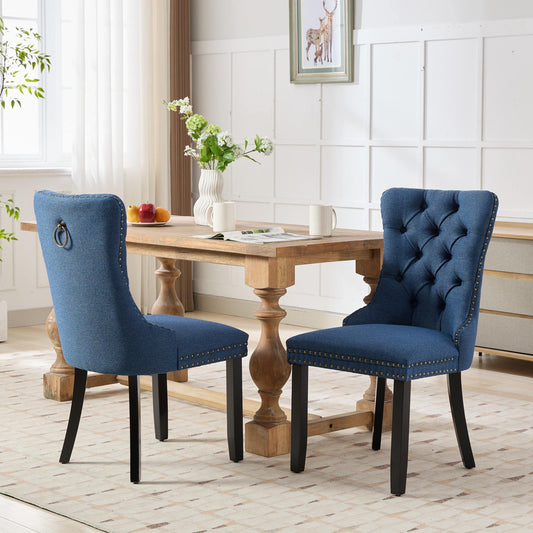 Blue tufted dining chair with brass nailhead trim and ring pull