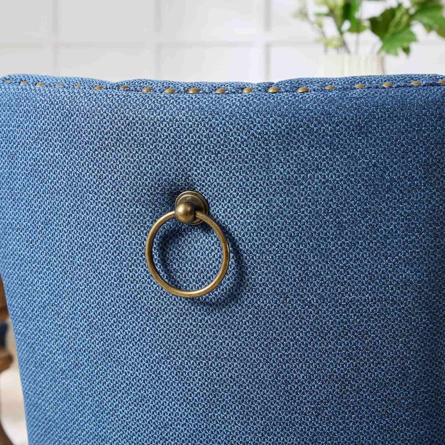 Blue textured fabric chair back with brass ring pull
