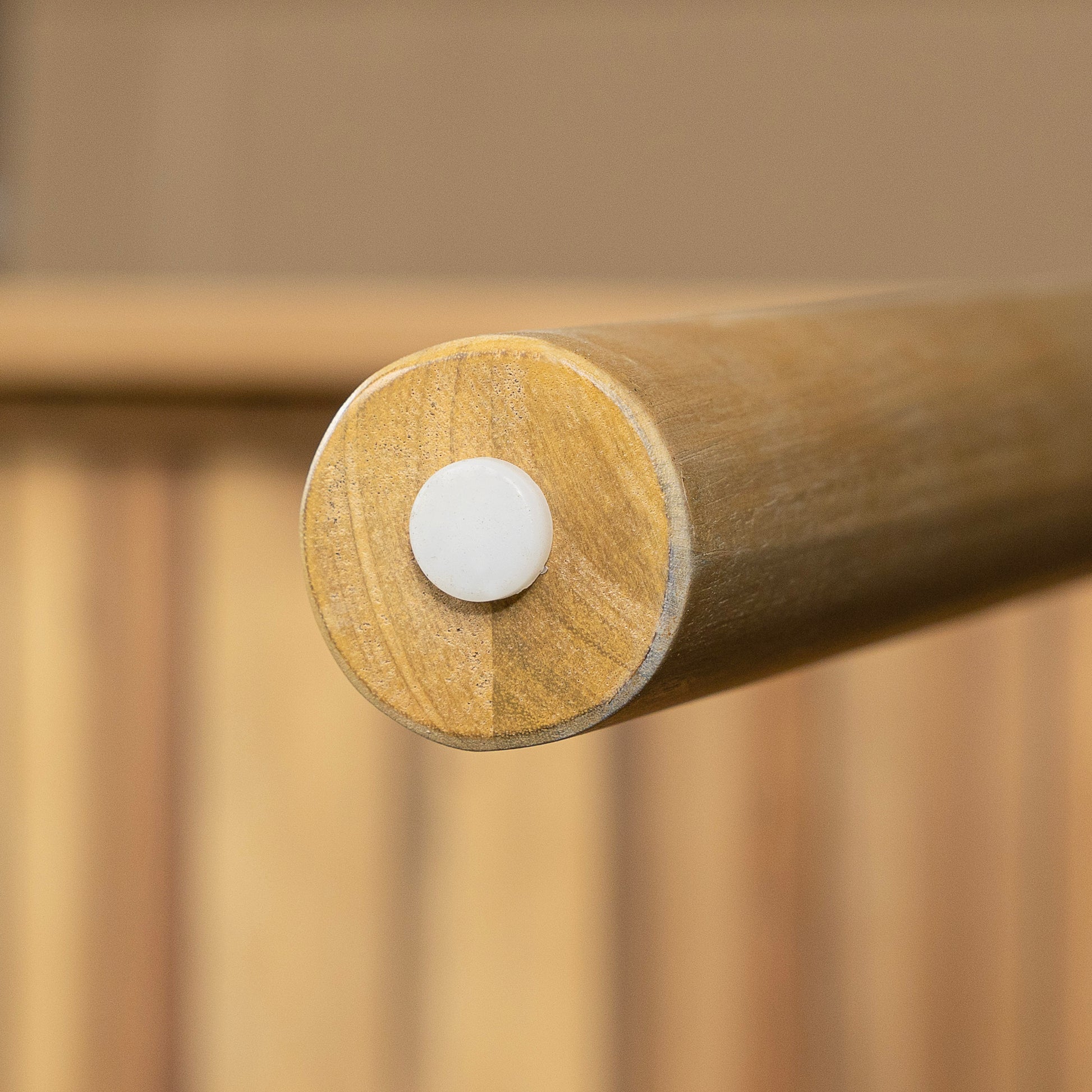 Close up of a wooden furniture leg with a white cap