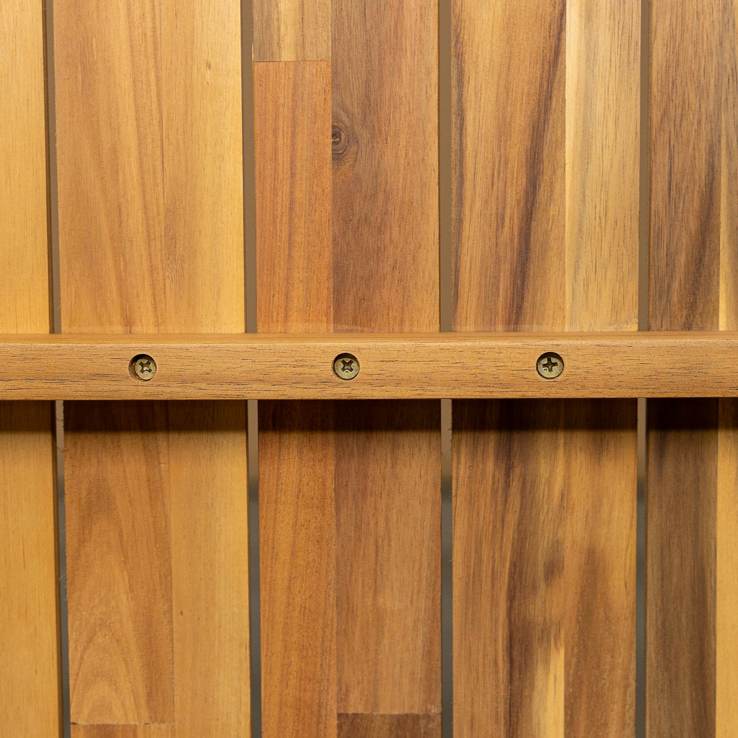 Closeup of natural wood planks with a horizontal wooden support beam secured by screws