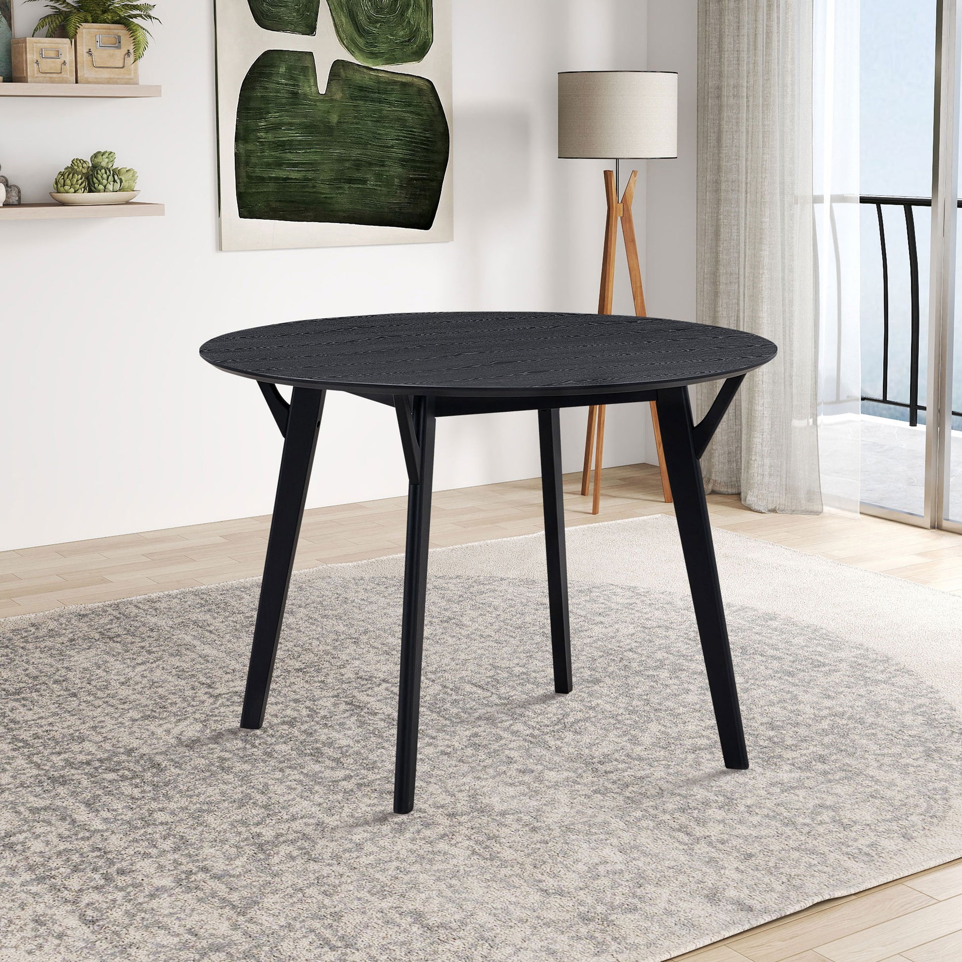 Black round oak dining table with textured top and tapered legs
