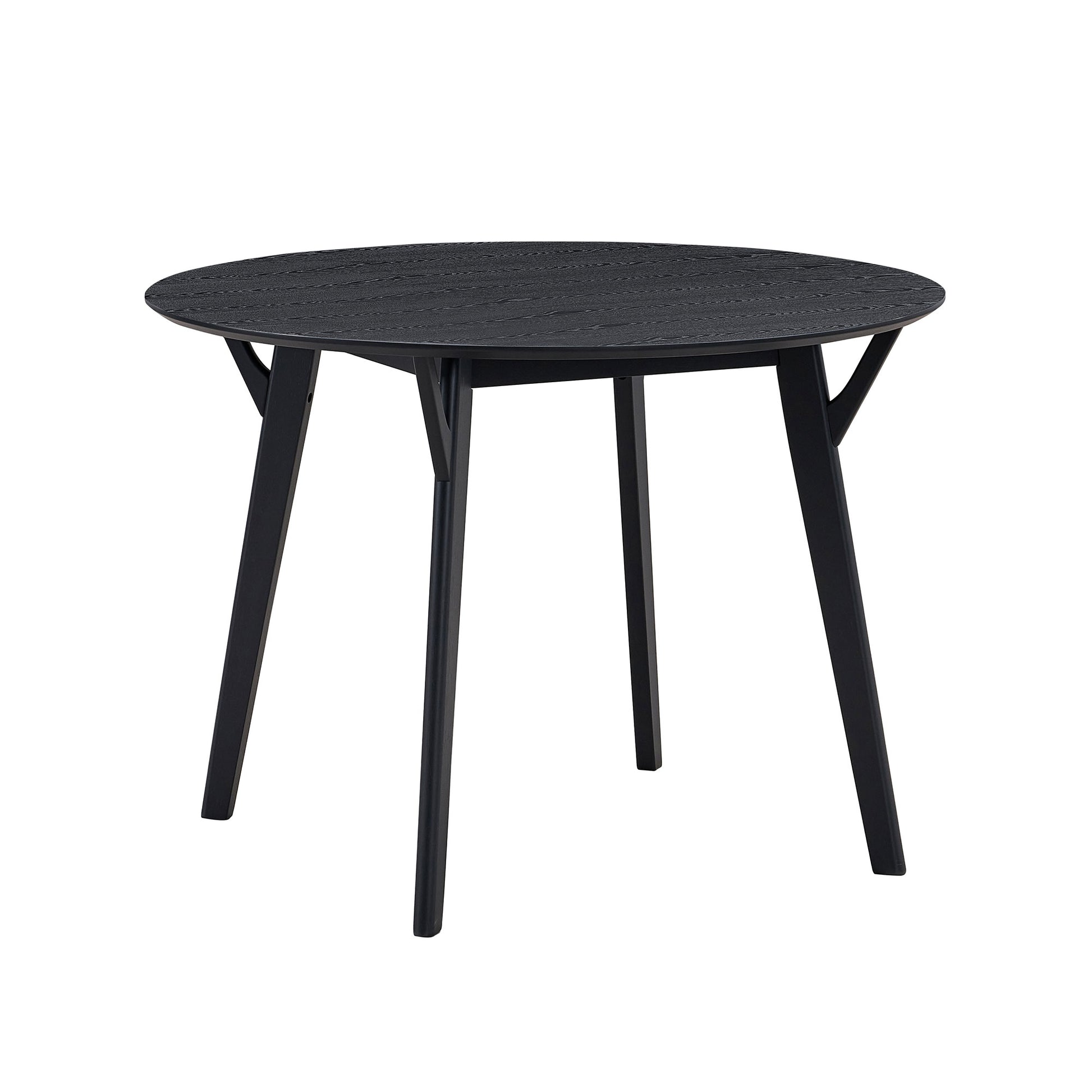 Black round dining table with textured surface and tapered legs